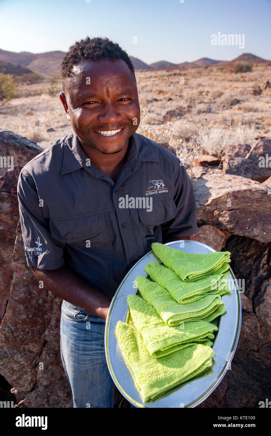 Mitarbeiter mit erfrischenden Willkommen Handtücher - Huab unter Leinwand, Damaraland, Namibia, Afrika Stockfoto