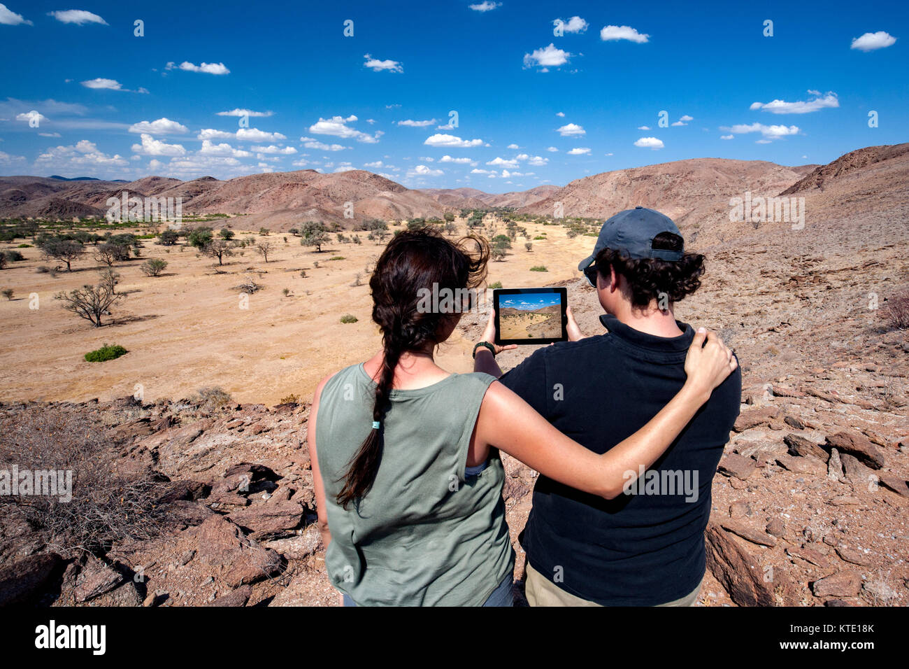 Paar mit Tablette im Damaraland - Huab unter Leinwand, Damaraland, Namibia, Afrika Stockfoto