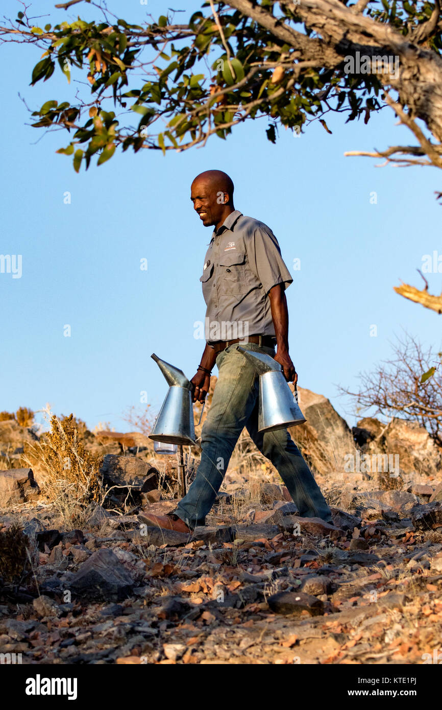 Mitarbeiter, die Wasser in Blechdosen in Huab unter Leinwand, Damaraland, Namibia, Afrika Stockfoto