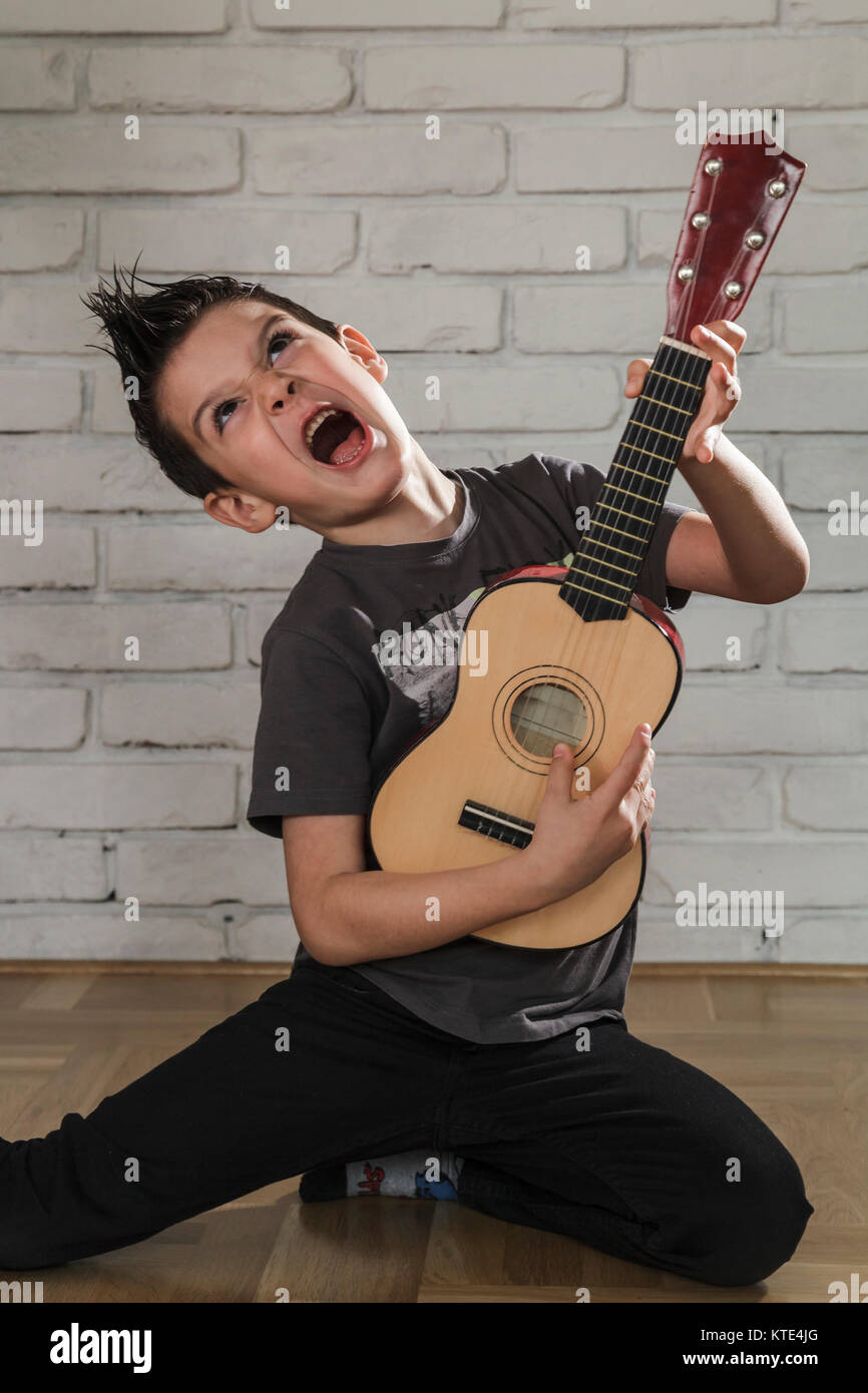 Glückliche junge spielt Gitarre Stockfoto