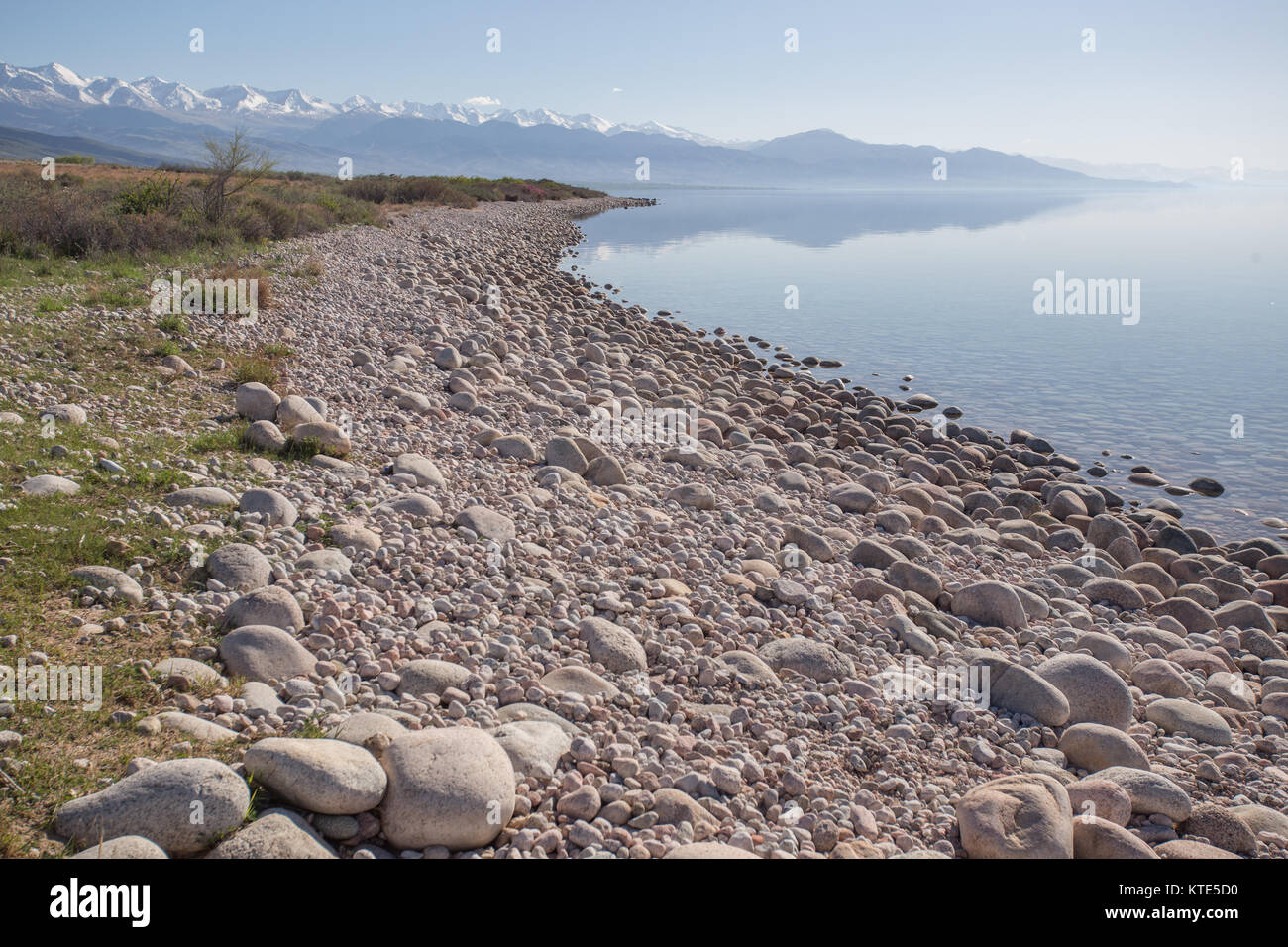 Spiegelungen der Berge in den stillen Gewässern am Südufer des Issyk-Kol-Sees in Kirgisistan. Stockfoto