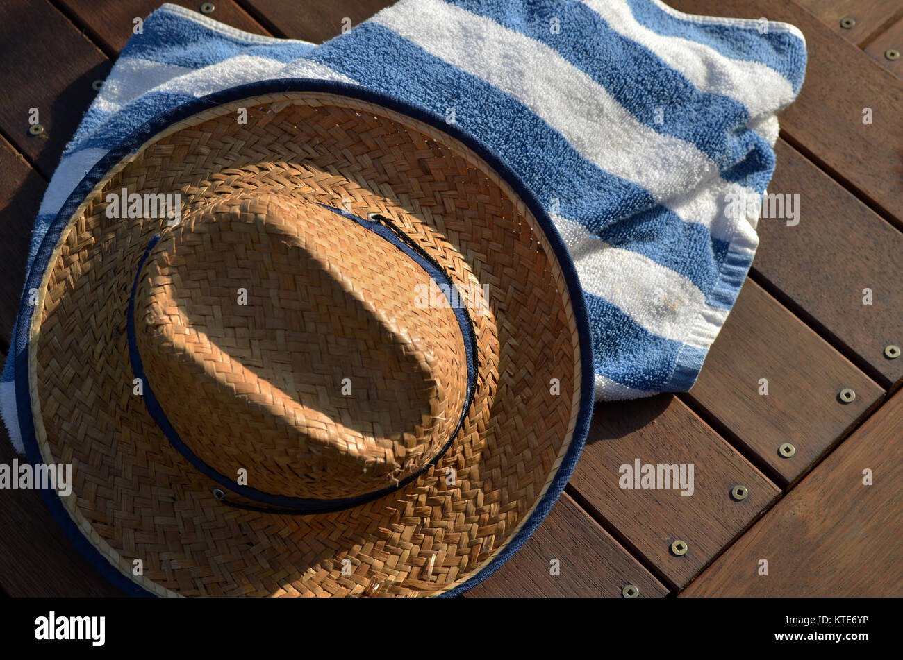 Stroh Beach Hut und gestreifte Strandtuch auf hölzernen Deck Stockfoto