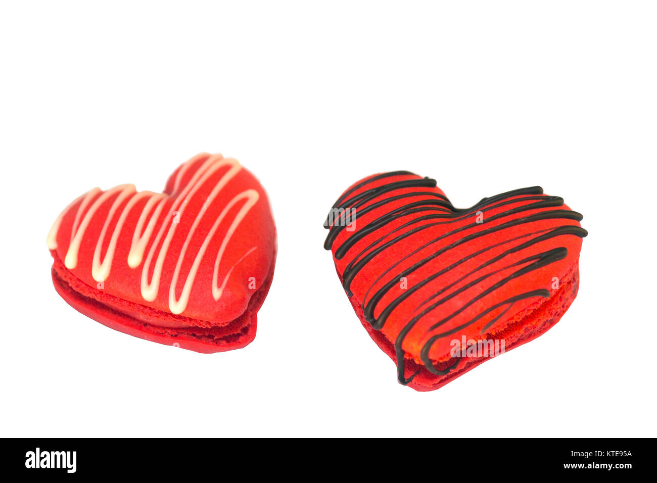Herzförmige Makronen am Valentinstag, mit Schokolade bespritzt, auf weißem Hintergrund Stockfoto