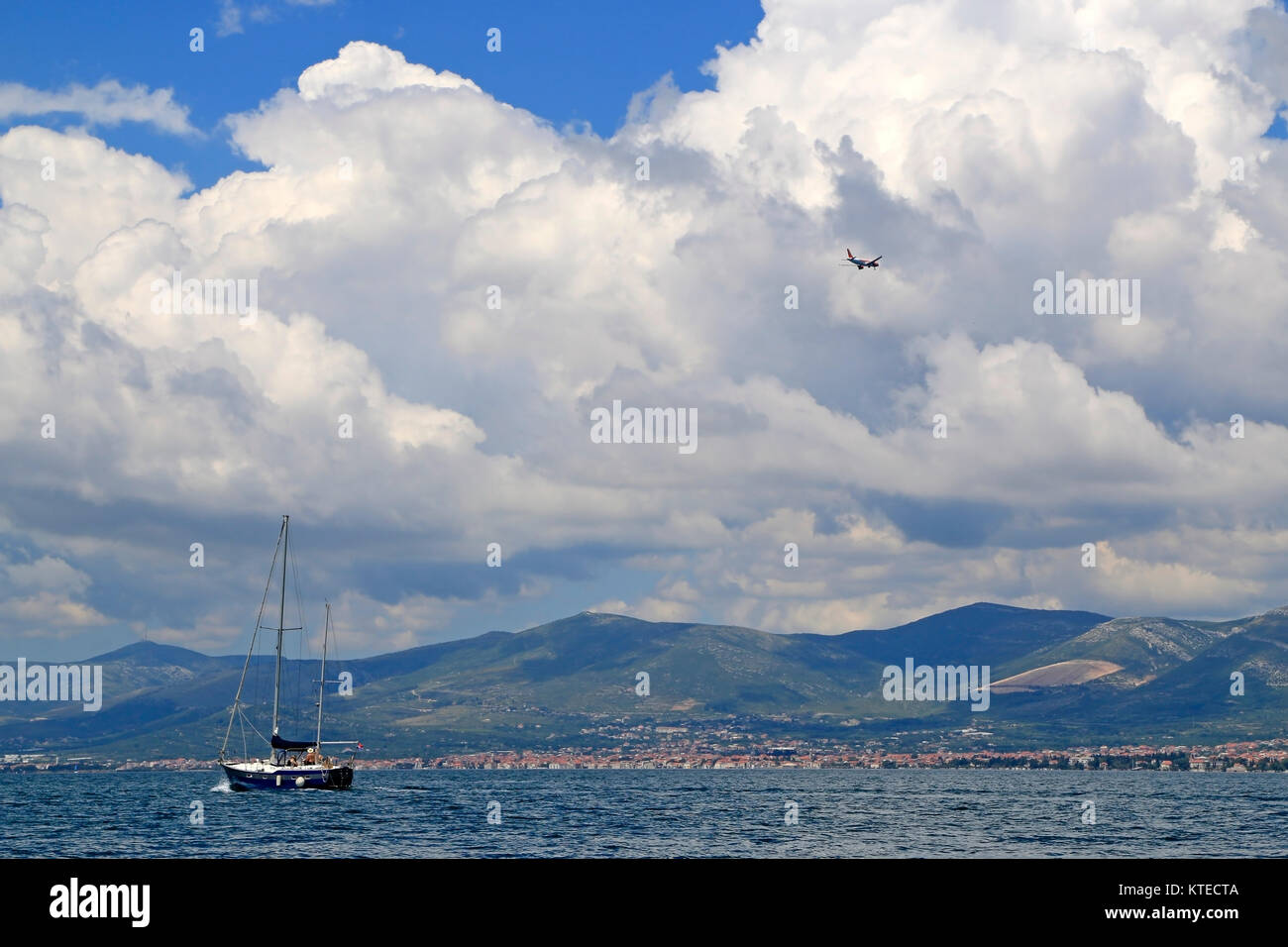 Kastela Bucht, Kroatien - Juni, 04, 2016: Verkehr über die Kastela Bucht, Segelboot auf das Meer, Flugzeug auf dem Himmel Stockfoto