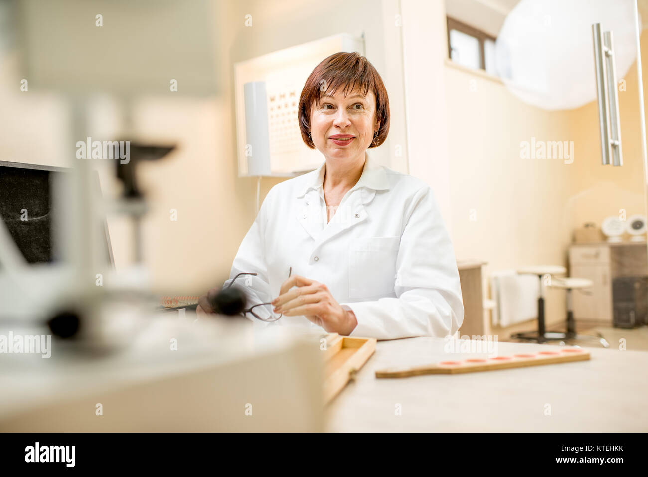 Porträt einer älteren Frau Augenarzt in unifrom Verfassen wissenschaftlicher Arbeiten im Büro Stockfoto
