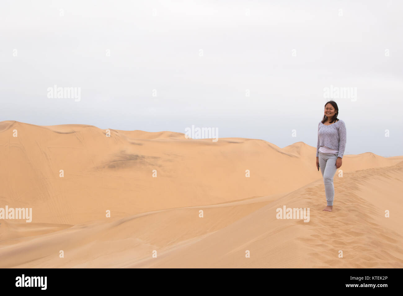 Ein indonesisches Mädchen Posen auf Dune 7, die höchste Sanddüne der Welt, in Walvis Bay, Namibia Stockfoto