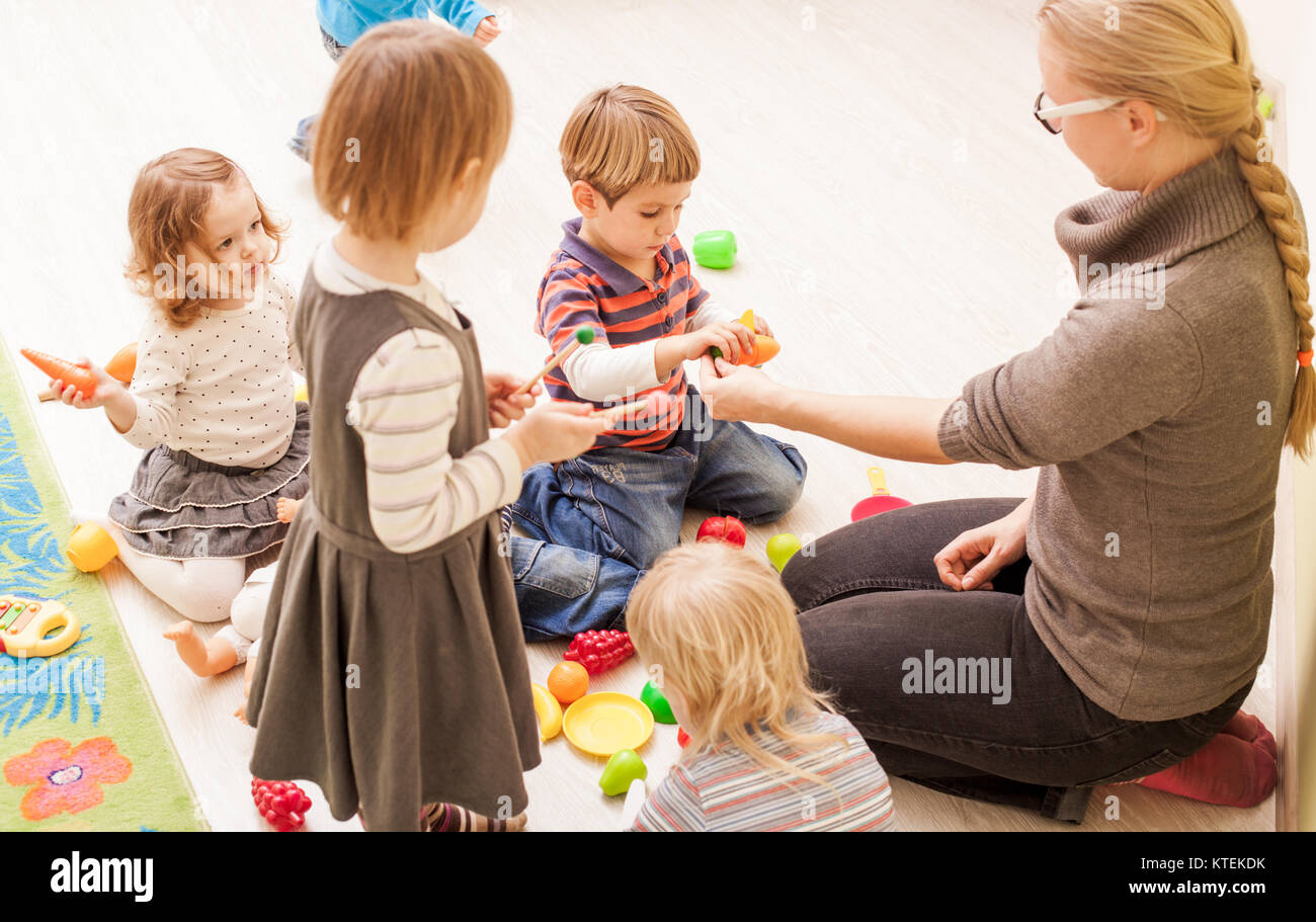 Kinder mit dem Lehrer im Kindergarten spielen Köche Stockfoto