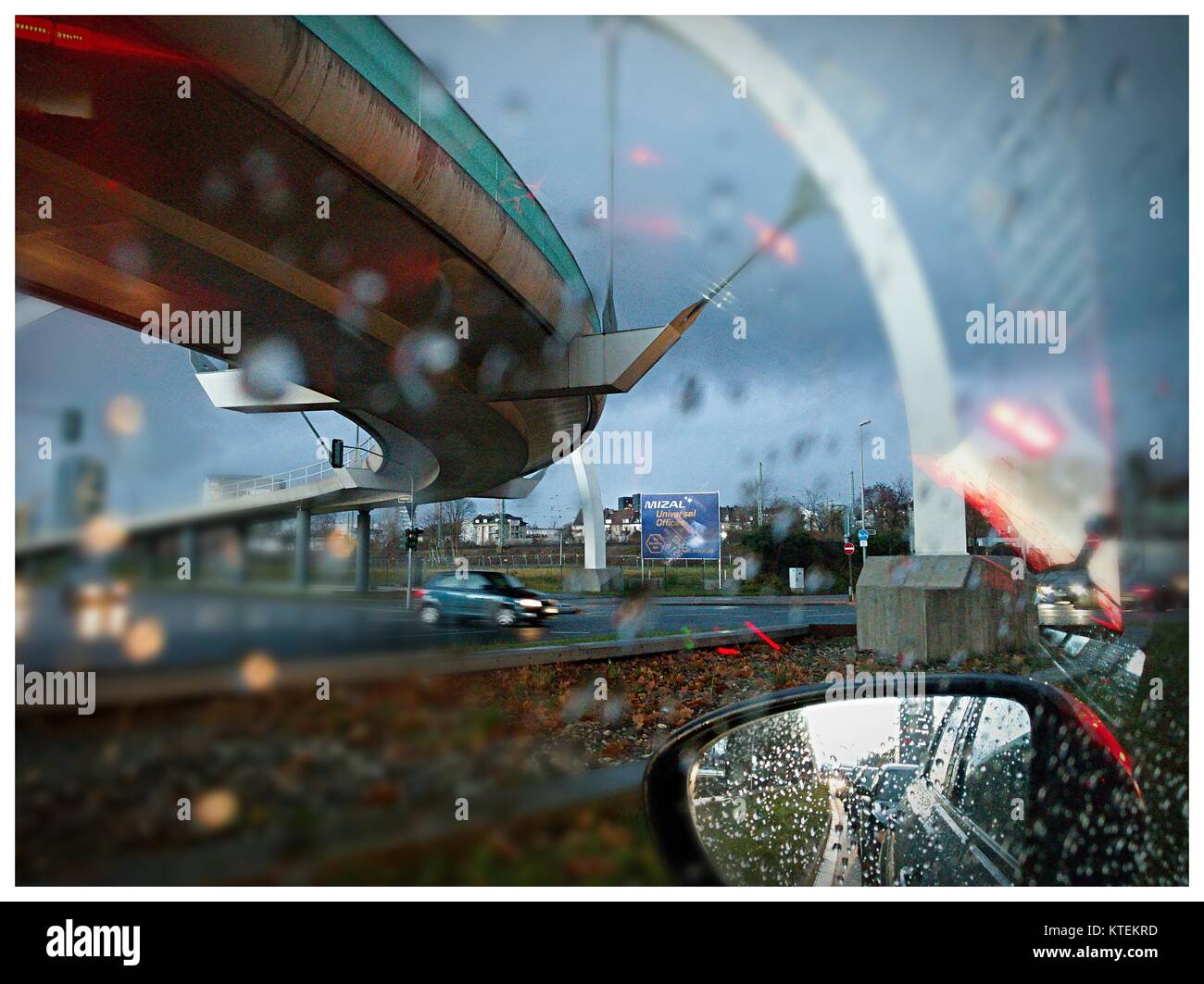 Treiber Blick durch die Windschutzscheibe mit Regentropfen auf städtischer Verkehr und Straßen in Düsseldorf Zentrum Stockfoto