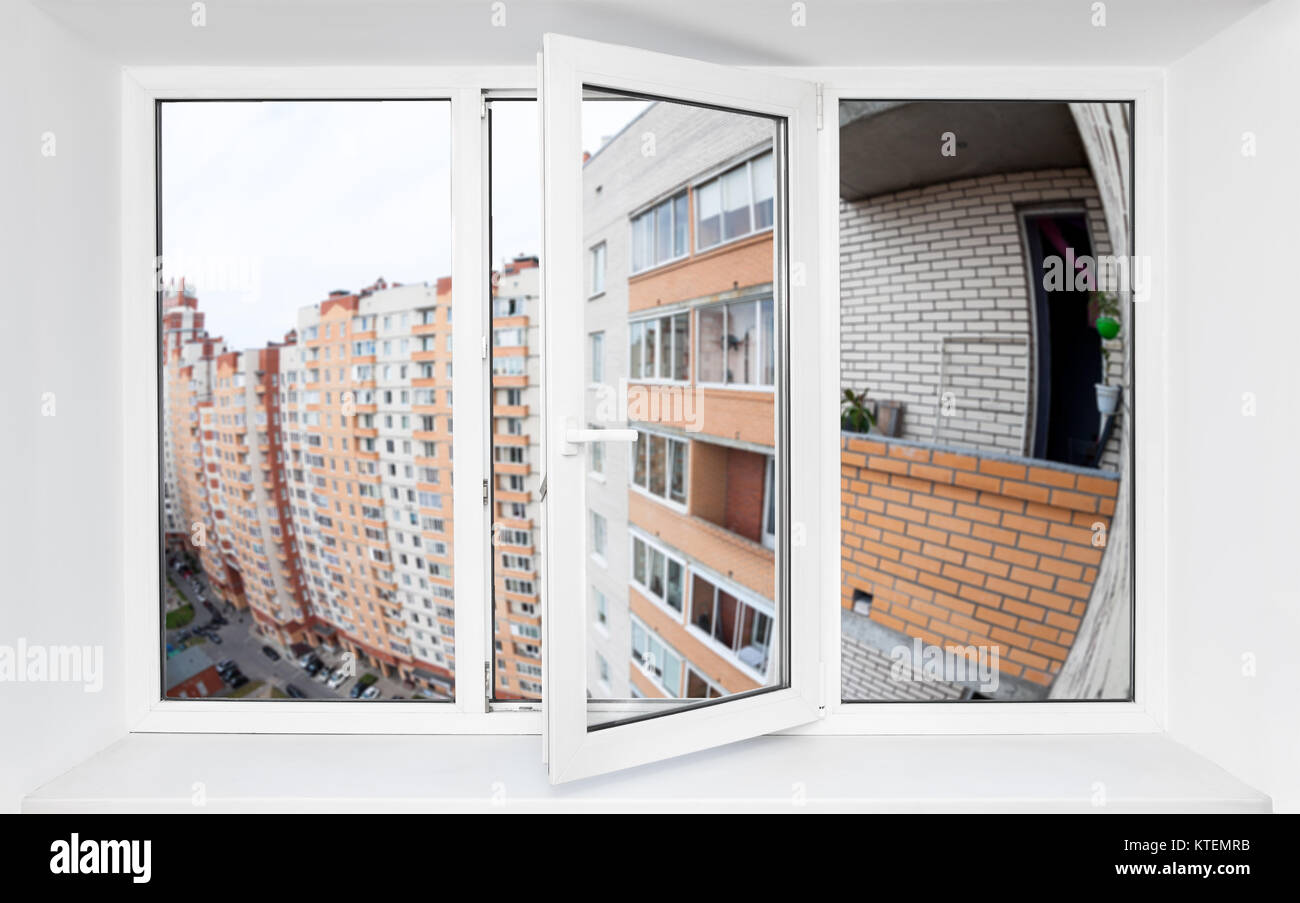 Triple-casement pvc-fenster mit Blick auf die Fassade des Multi-Wohnung mit Balkon Stockfoto