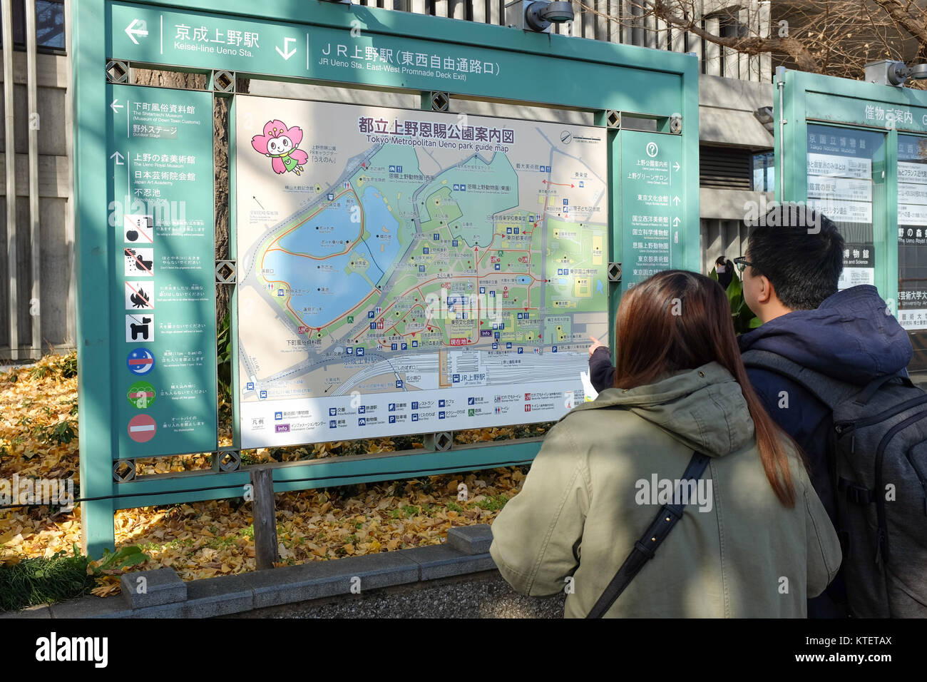 Zwei junge Menschen studieren eine Karte von Ueno Park in Tokio, Japan. Stockfoto