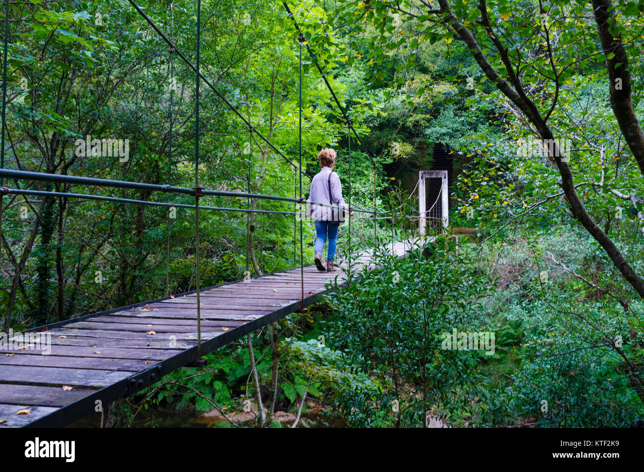 Eine Frau geht auf einer Hängebrücke über den Fluss Sor. Mañon, Provinz A Coruña, Galicien, Spanien, Europa Stockfoto