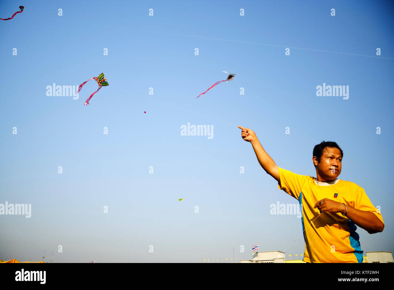 Thai Mann fliegende Drachen während Magha Puja am Sanam Luang offenes Feld und öffentlichen Platz vor der Wat Phra Kaew und den Großen Palast, Bangkok, Thailand. Stockfoto