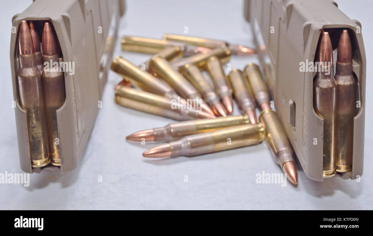 Zwei braune Gewehr Zeitschriften mit .223 Umläufe und mehrere Runden neben Ihnen auf einem weißen Hintergrund geladen Stockfoto
