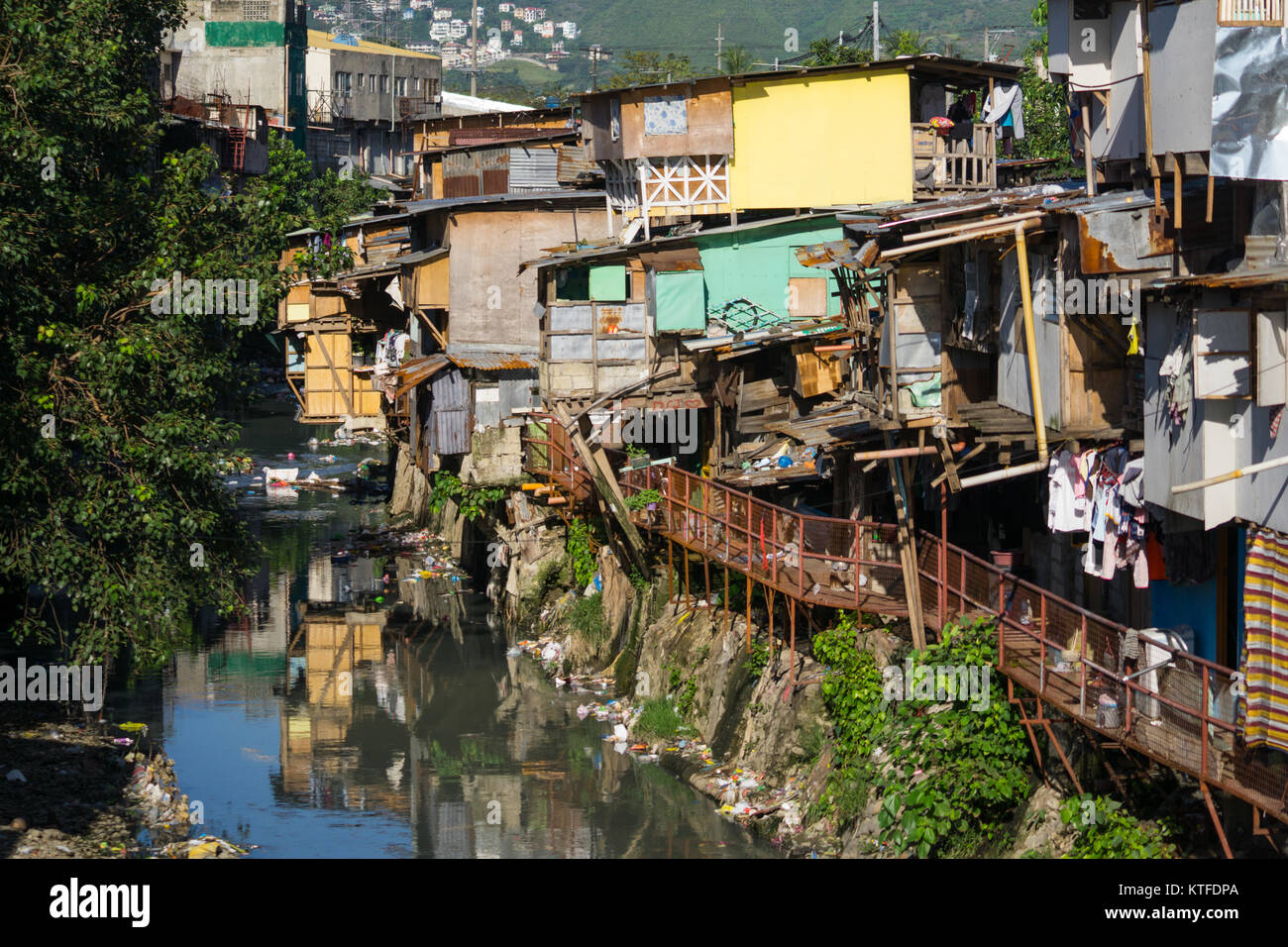 Typische schlechte Wohnverhältnisse, Bauwerke aus leichten Materialien, ragt heraus über einen Bach, wo alle die Abfälle, Leergut, Cebu City, Philippinen Stockfoto