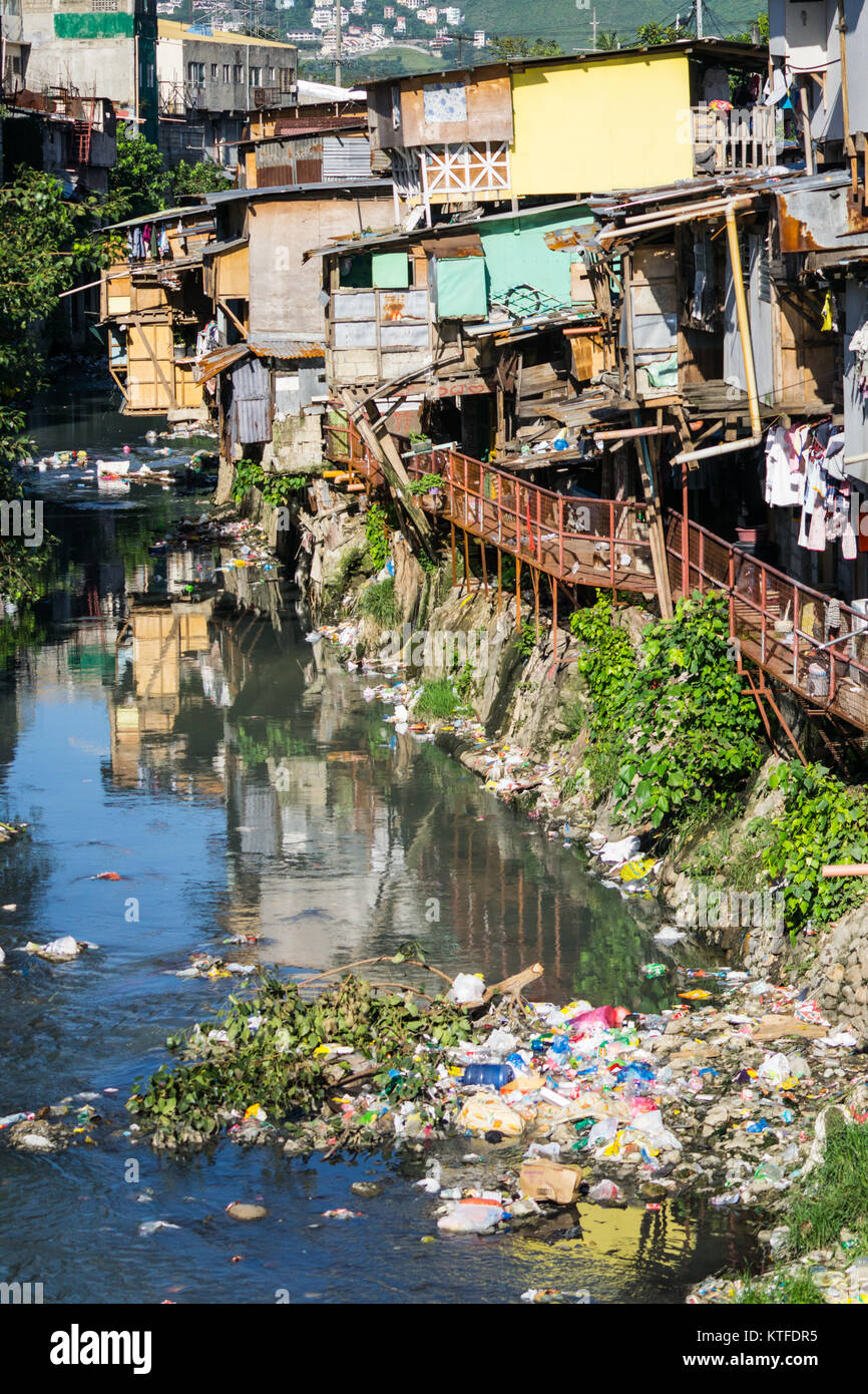 Typische schlechte Wohnverhältnisse, Bauwerke aus leichten Materialien, ragt heraus über einen Bach, wo alle die Abfälle, Leergut, Cebu City, Philippinen Stockfoto