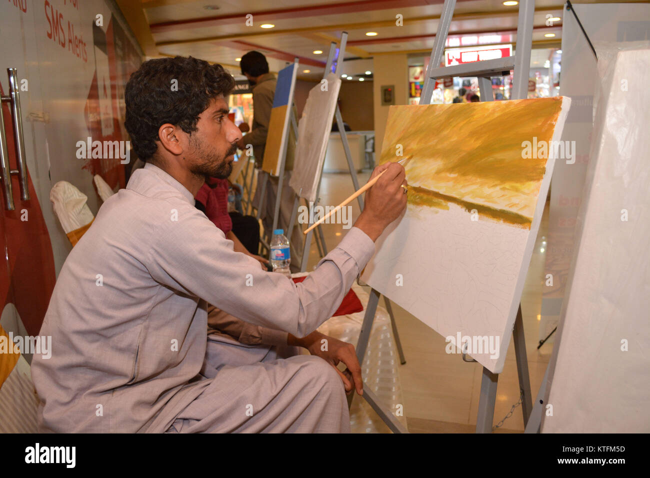 QUETTA, Pakistan. Dez-24 2017: Künstler aus verschiedenen Akademien und Kunst jedes Windsurfniveau Zeichnung die Malerei während Bildende Kunst Wettbewerb Dürre widerstandsfähige Landwirtschaft Modellierung im Millennium Mall in Quetta, Pakistan. Organisiert von Islamic Relief Stockfoto