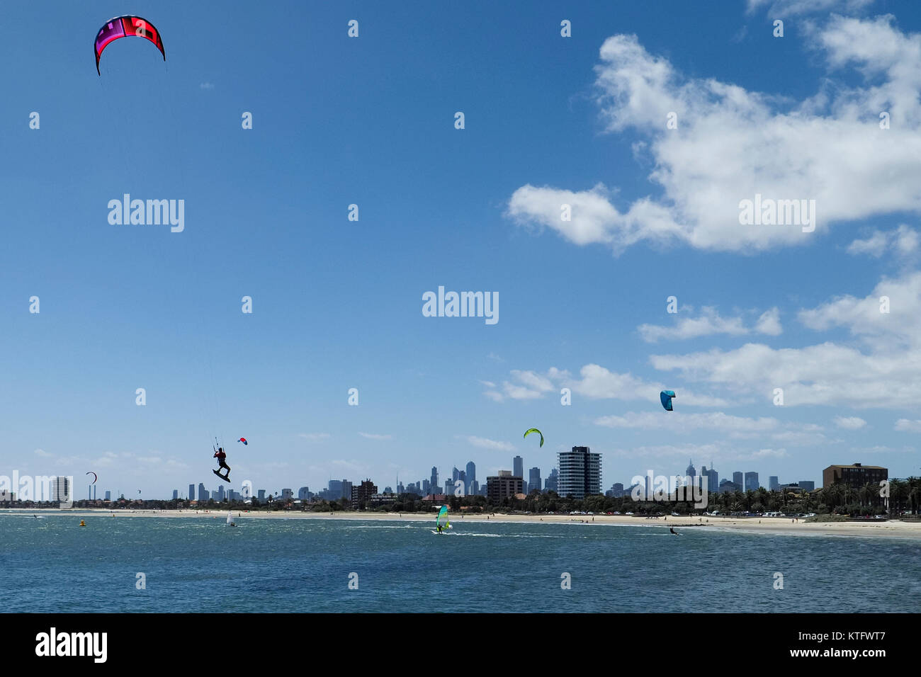 St. Kilda Beach, Melbourne, Australien. 25. Dezember 2017. Kitesurfer und Windsurfer verbringen Weihnachten genießen den Wind und Sonne auf dem Wasser von St. Kilda Beach mit der Stadt Melbourne Skyline in der Ferne. Credit: © mehul Patel/Alamy leben Nachrichten Stockfoto