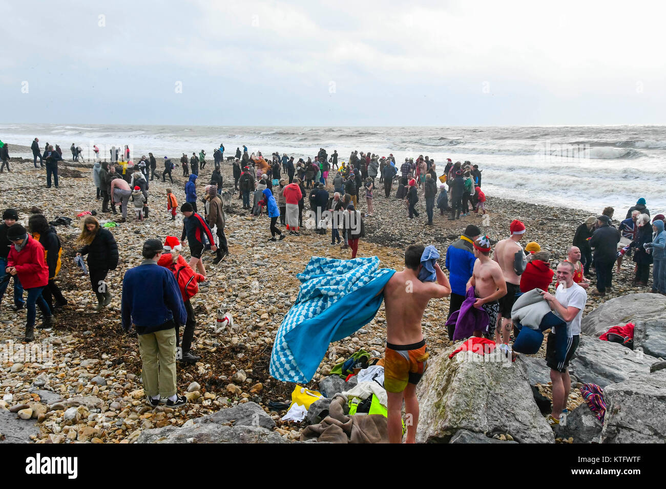 Charmouth, Dorset, Großbritannien. 25. Dezember 2017. Die Menschen gekleidet in Kostüme tapfer den kühlen Wind und rauer See für den Weihnachtstag bei Charmouth Beach in Dorset schwimmen. Die Schwimmen wurde offiziell von der RNLI abgebrochen aber hardy Nachtschwärmer nahm sowieso auf die rauhe See. Foto: Graham Jagd-/Alamy leben Nachrichten Stockfoto