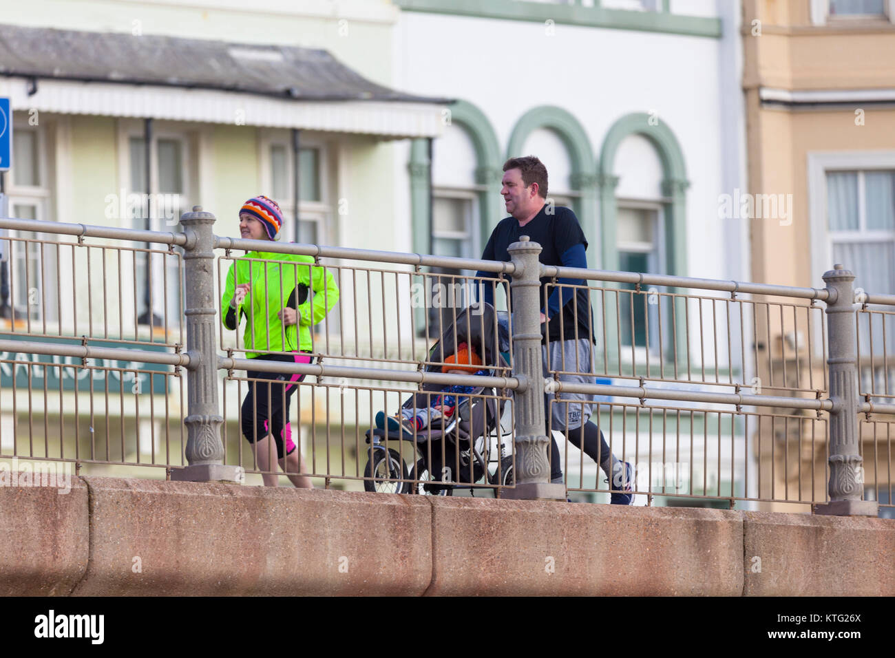 Hastings, East Sussex, UK. 26. Dezember 2017. Viele Leute unterwegs und genießen den milden Boxing Day Wetter heute Morgen. Dieses Paar nehmen den Kinderwagen für ein Jog. Foto: Paul Lawrenson/Alamy leben Nachrichten Stockfoto