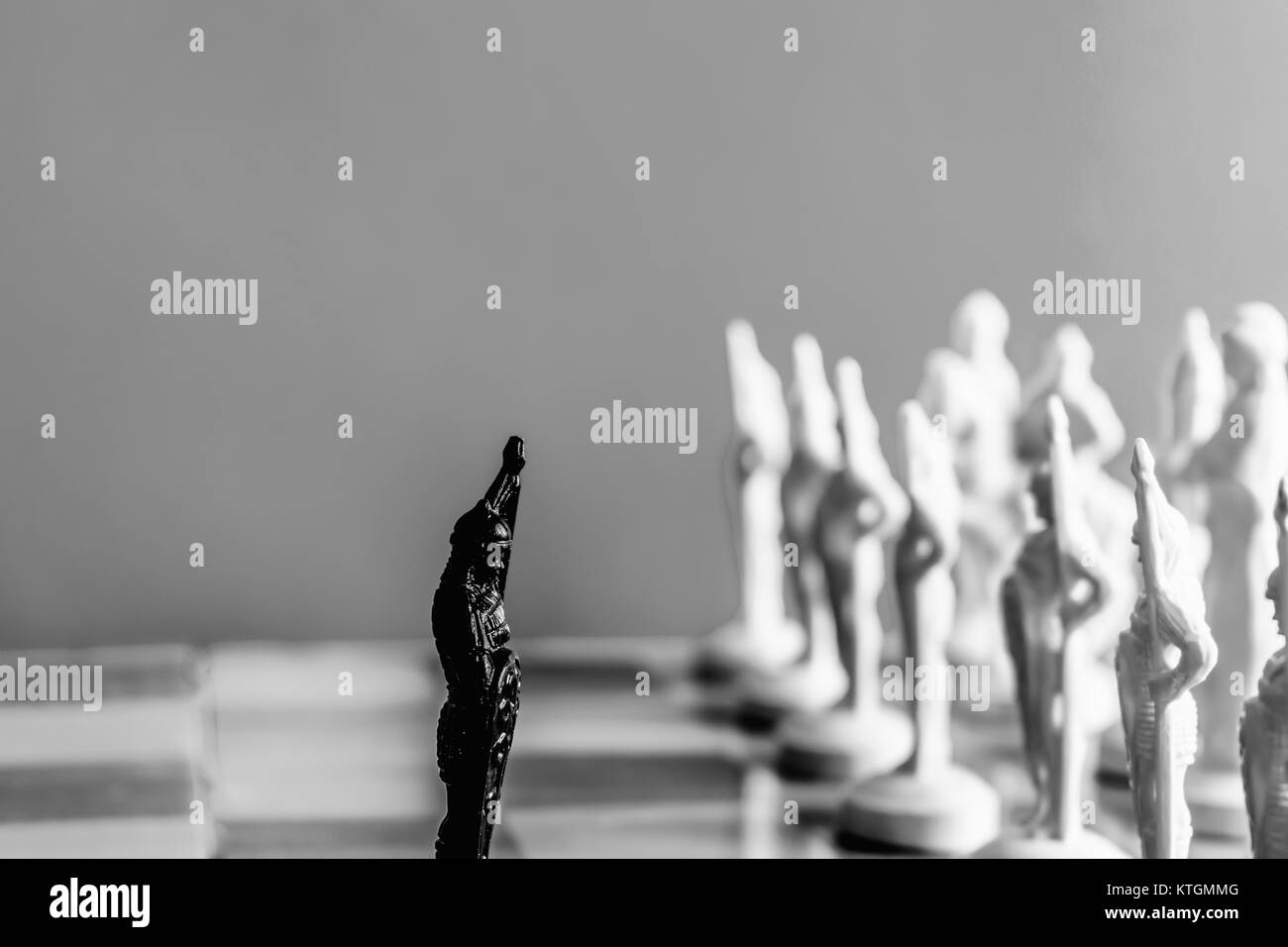 Schach auf weißen schwarzen Hintergrund. Eine schwarze Bauer steht vor einer feindlichen Armee Stockfoto