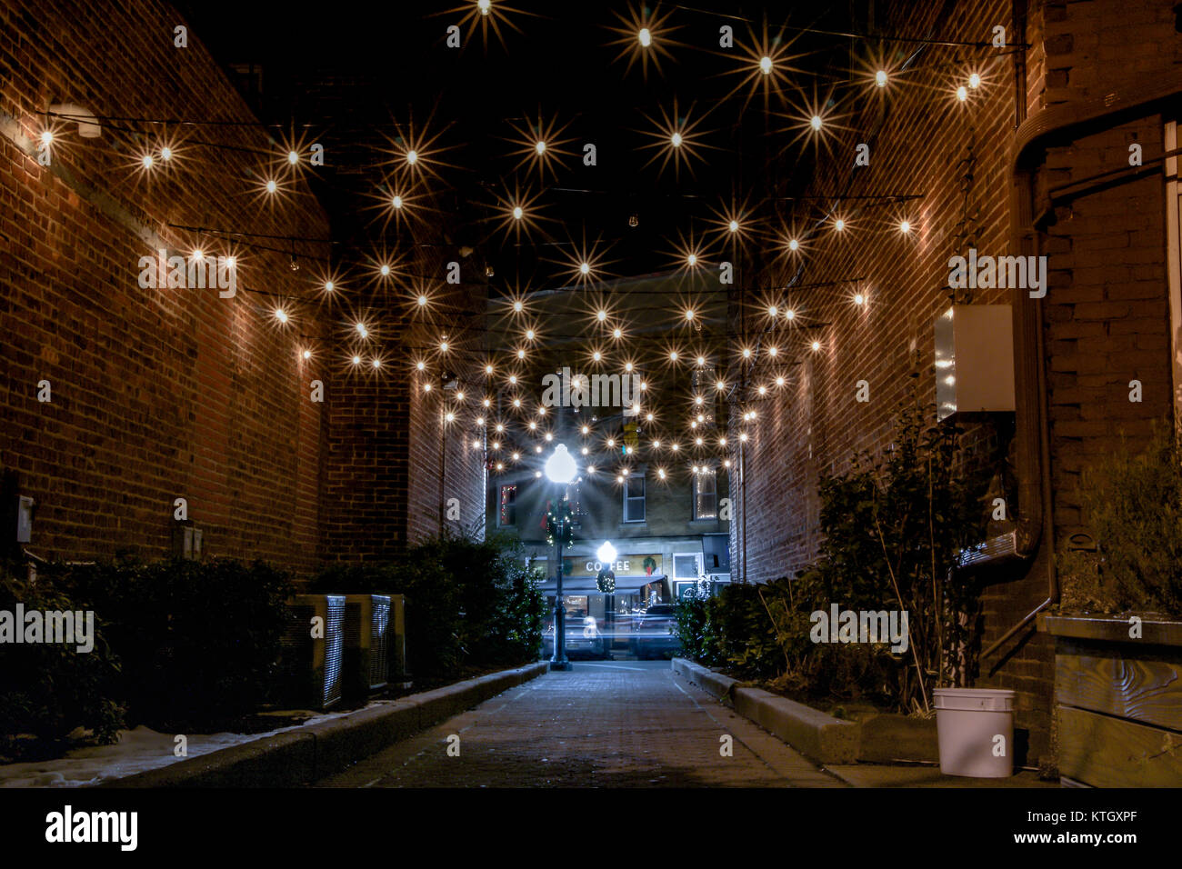 Äußere nachts lange Belichtung Foto von elektrischen Lichter über die Gasse vor Coffee Shop in Rahway, New Jersey im Union County hängen Stockfoto
