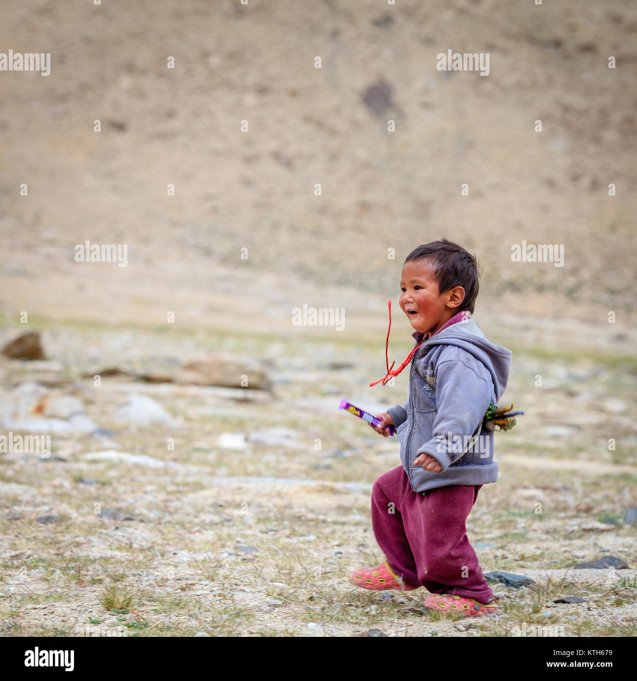 Ladakh, Kaschmir, Indien, 16. Juli 2016: Lokaler Junge läuft in das Feld im Hochland von Ladakh Bezirk von Kaschmir, Indien Stockfoto