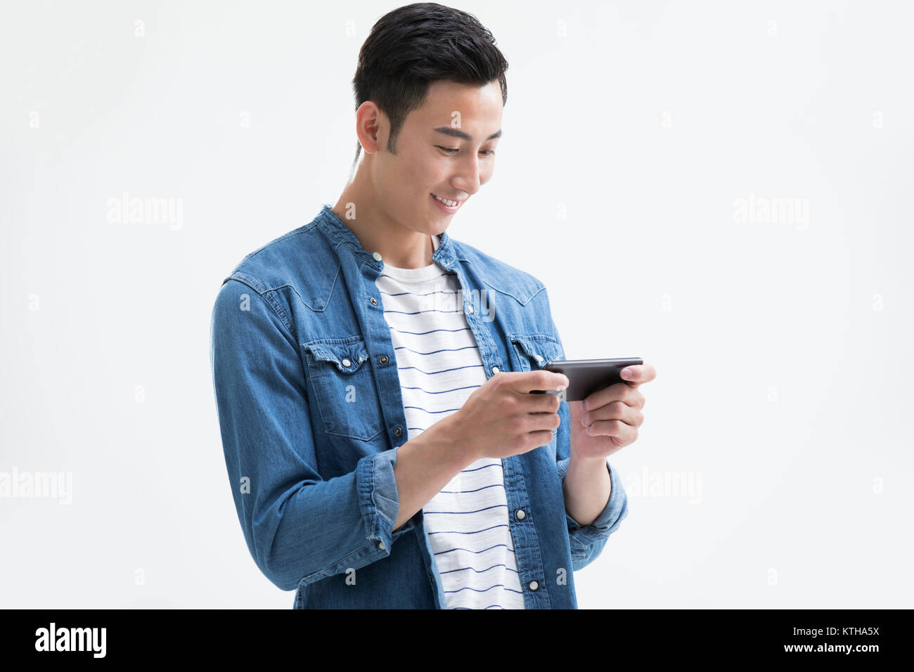 Junger Mann spielen mobile Spiele Stockfoto