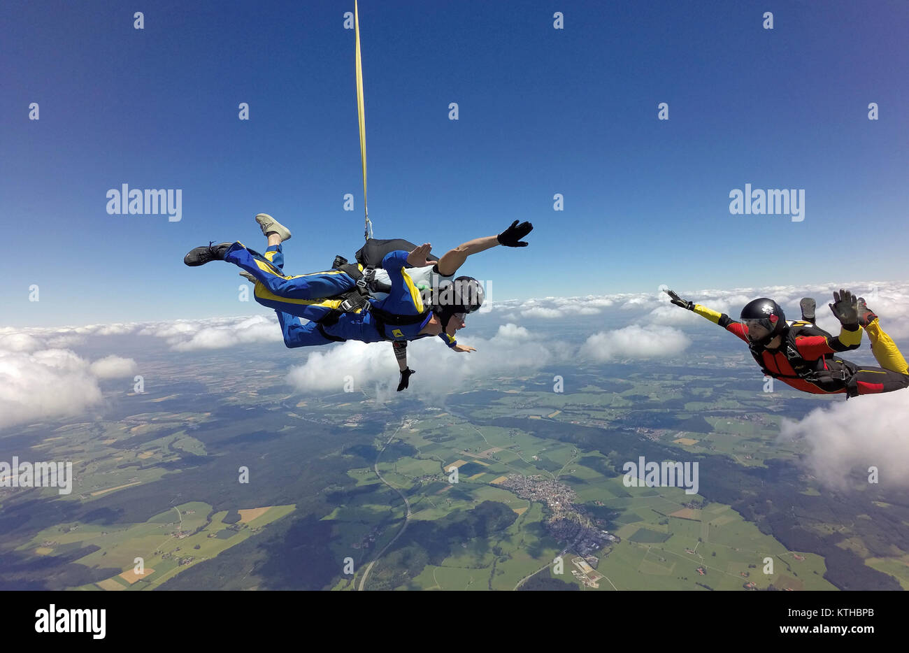 Dieses Tandem skydiving Paar, plus den Spaß Jumper sind, genießen Sie die großartige Landschaft über die wunderschöne landscapre Bereich. Die smiley-Gesichter prüfen! Stockfoto