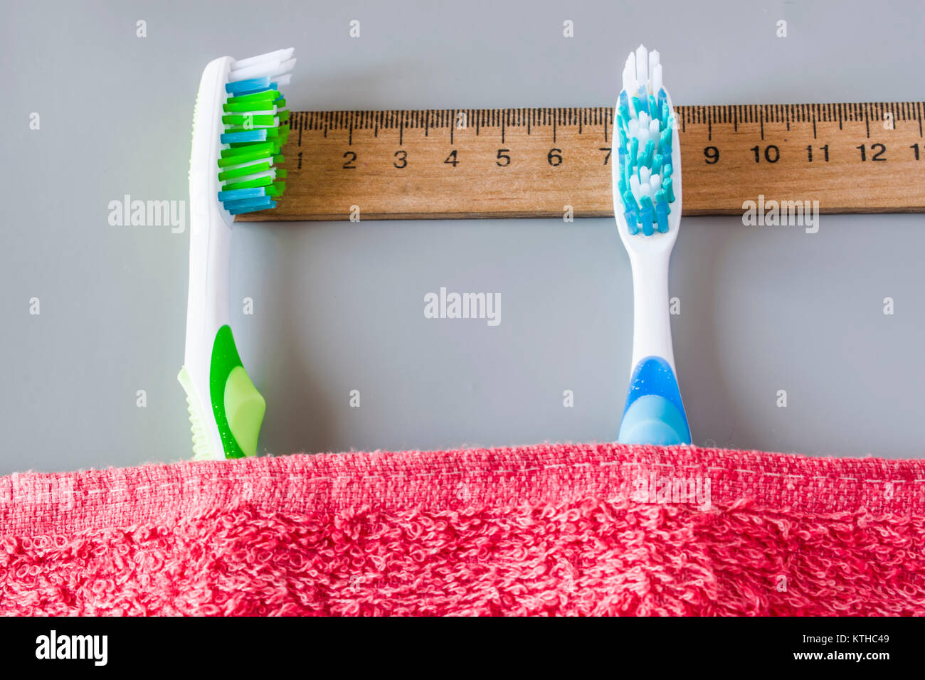 Kunststoff Zahnbürsten liegen auf dem Lineal unter dem Handtuch. Zeigt die Zeit an, die die Zähne putzen Stockfoto