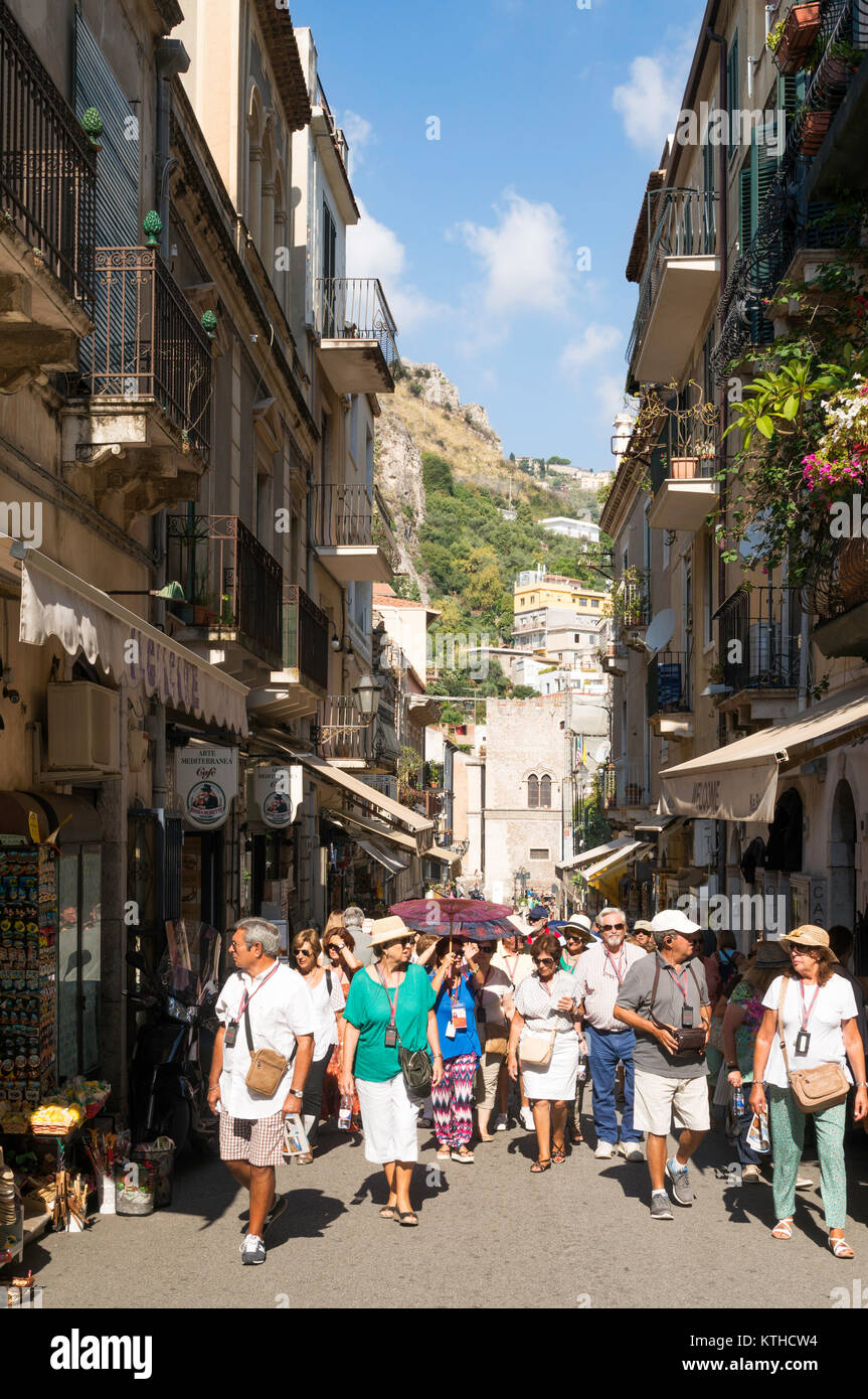 Gruppe der Touristen mit einem Reiseleiter zu Fuß durch die Altstadt von Taormina, Sizilien, Europa Stockfoto