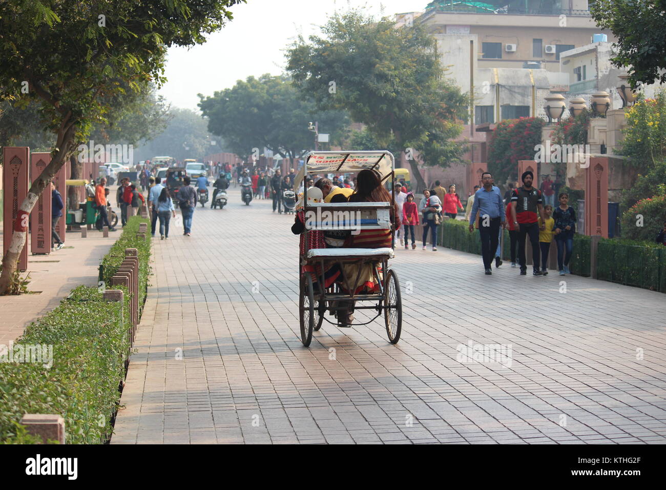 Cycle rickshaw mit Passagieren in Richtung Shilpgram von Taj Mahal von Taj East Gate Road, Agra. Touristen, die in Richtung Taj Mahal sind ebenfalls sichtbar. Stockfoto