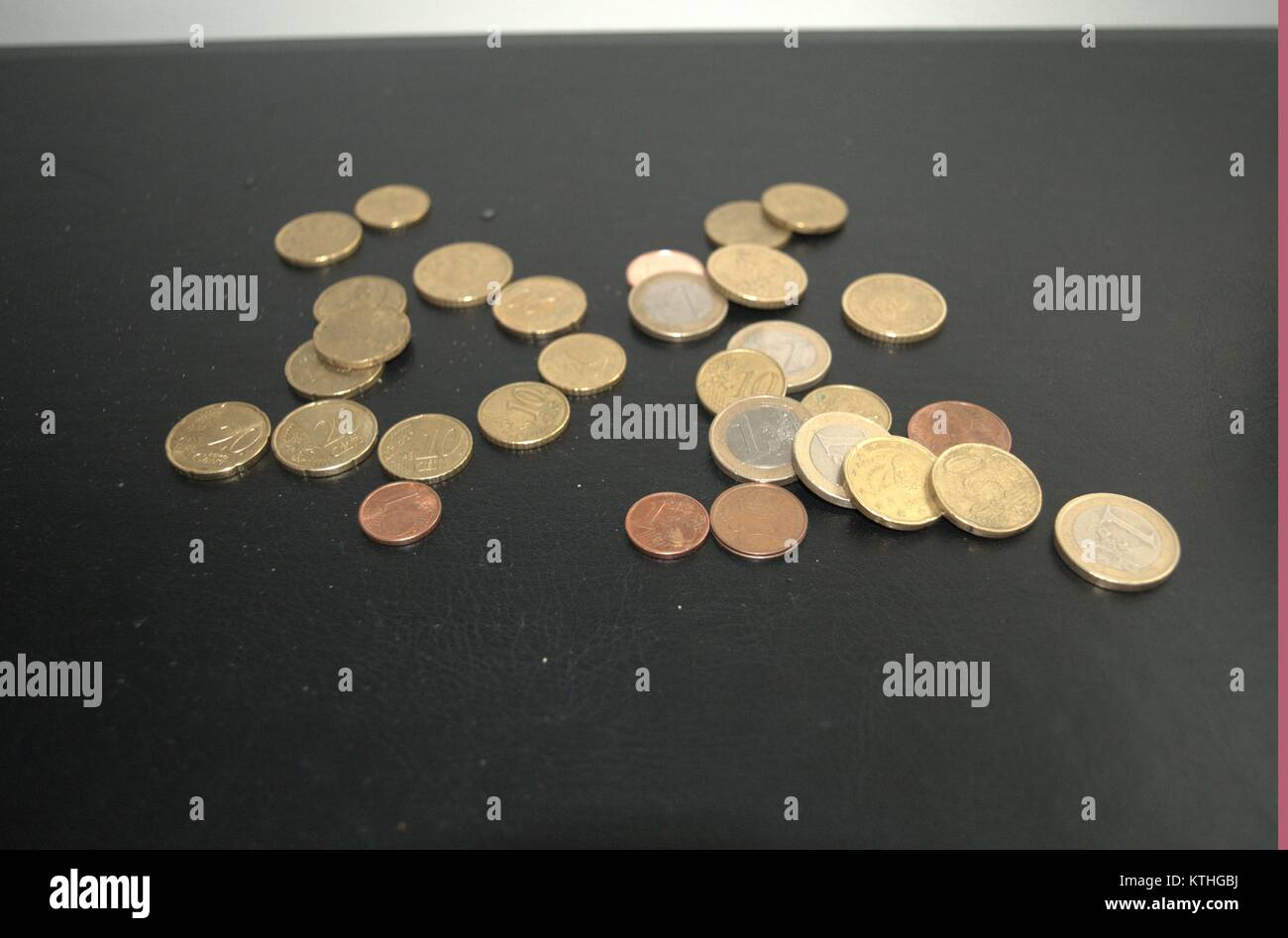 Einige Euro-Münzen und Pennies auf einem dunklen Hintergrund, den Menschen die Idee, Geld sparen in schlechten wirtschaftlichen Situationen. Achten Sie darauf, dass Sie ein Pfennig. Stockfoto