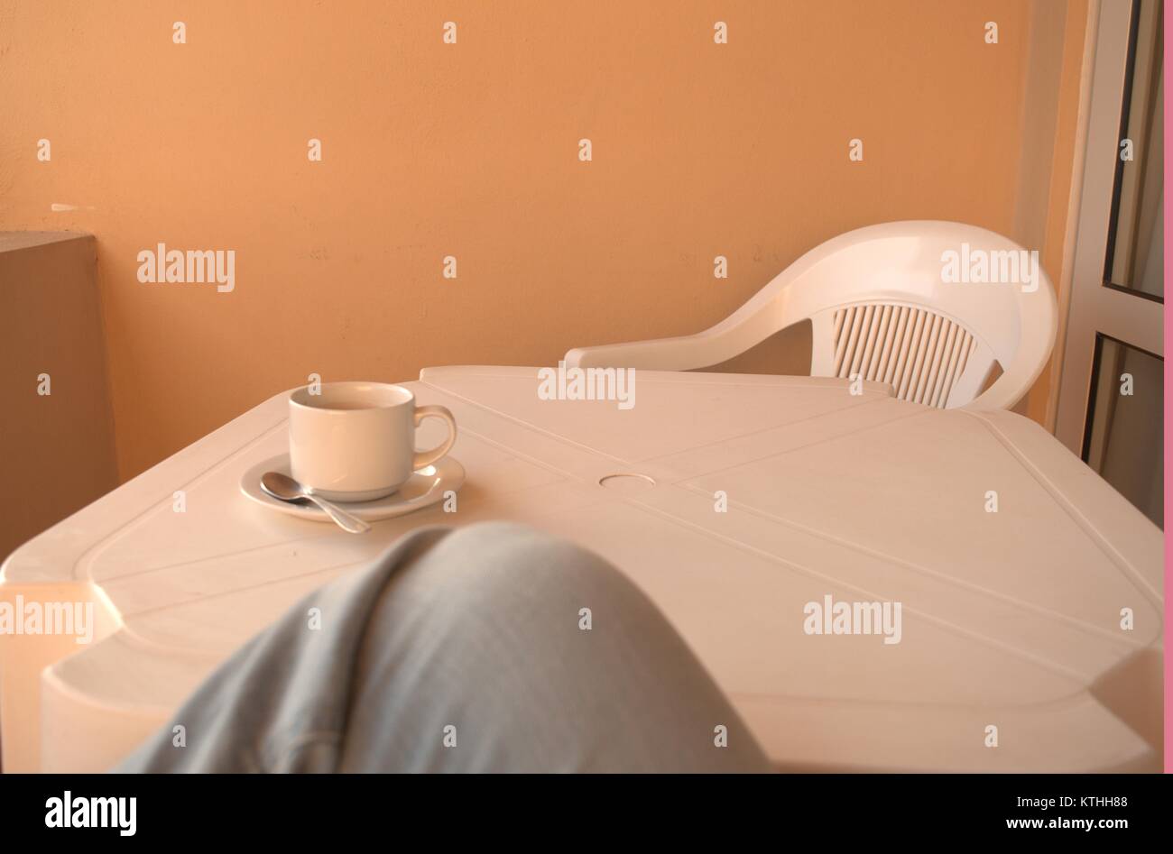 Eine warme bitteren Kaffee auf einem weißen Tisch mit einem Löffel und Untertasse unter warten auf jemanden, der sie in einen clod Wetter im Dezember 2017 zu trinken. Stockfoto