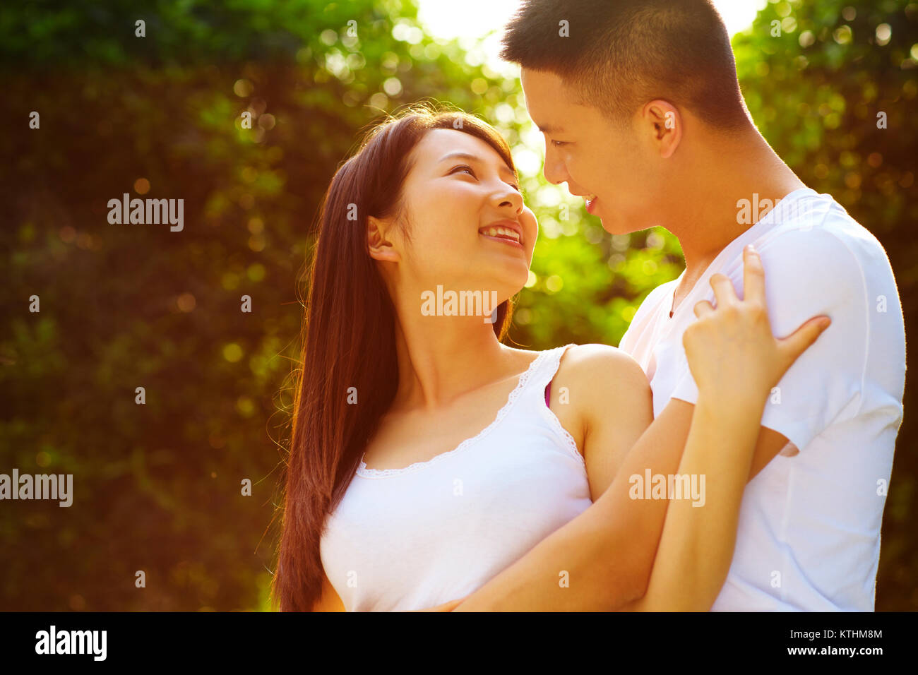 Junge chinesische Liebhaber zusammen Holding im Park Stockfoto