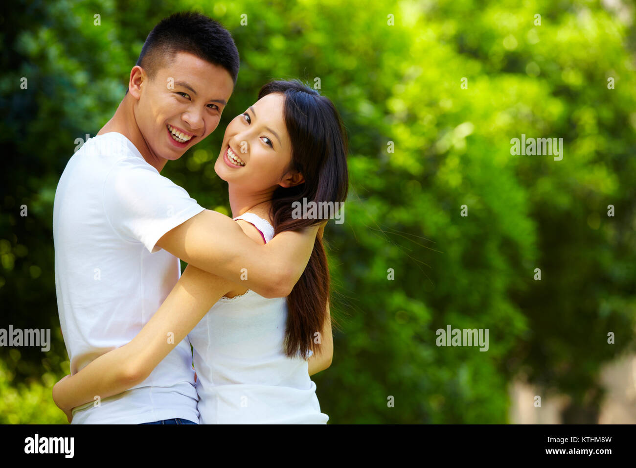 Junge chinesische Liebhaber zusammen Holding im Park Stockfoto