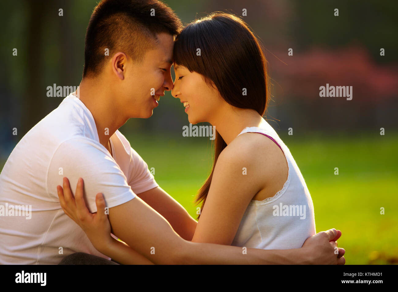 Junge chinesische Liebhaber zusammen Holding im Park Stockfoto