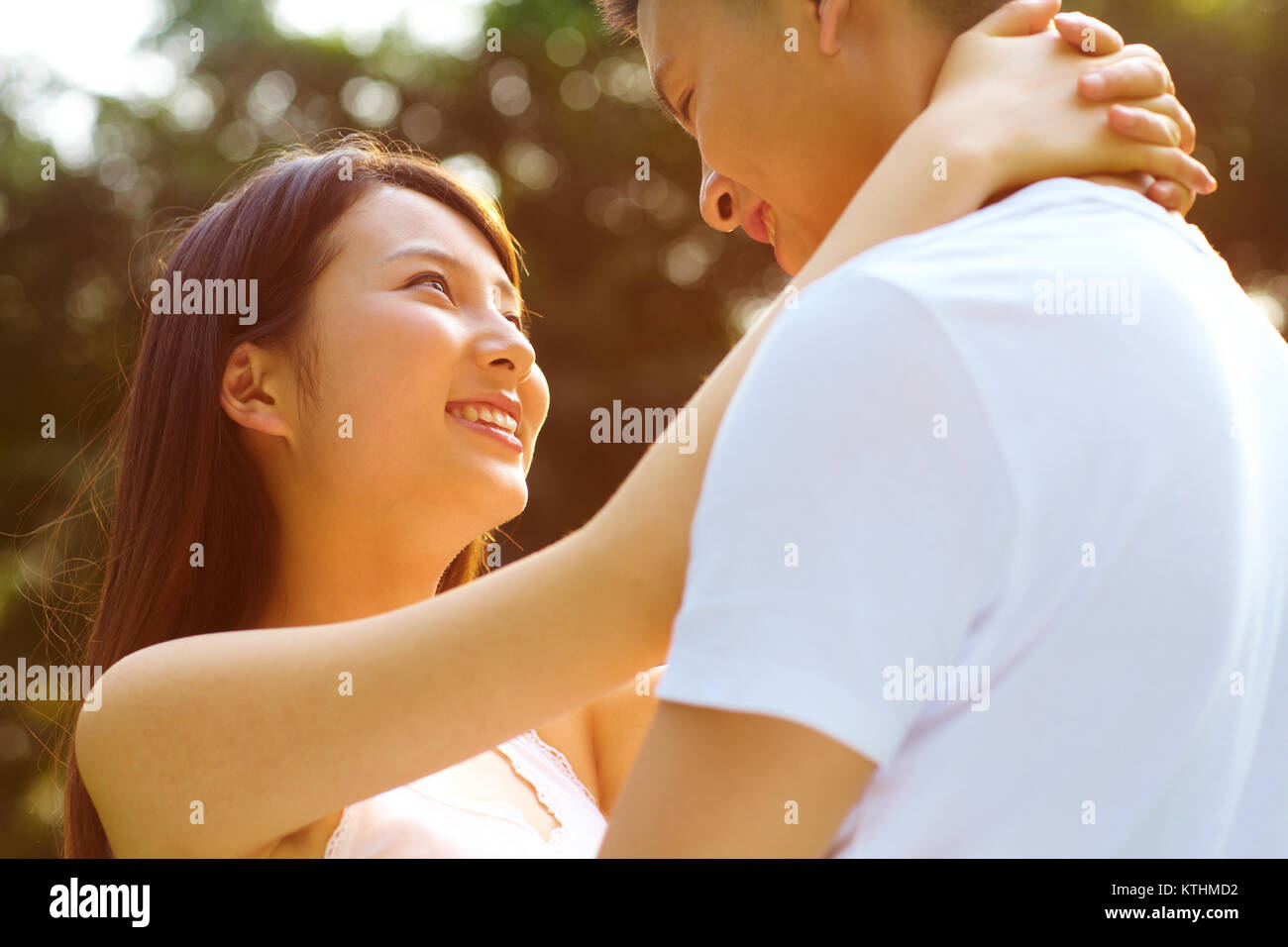 Junge chinesische Liebhaber zusammen Holding im Park Stockfoto