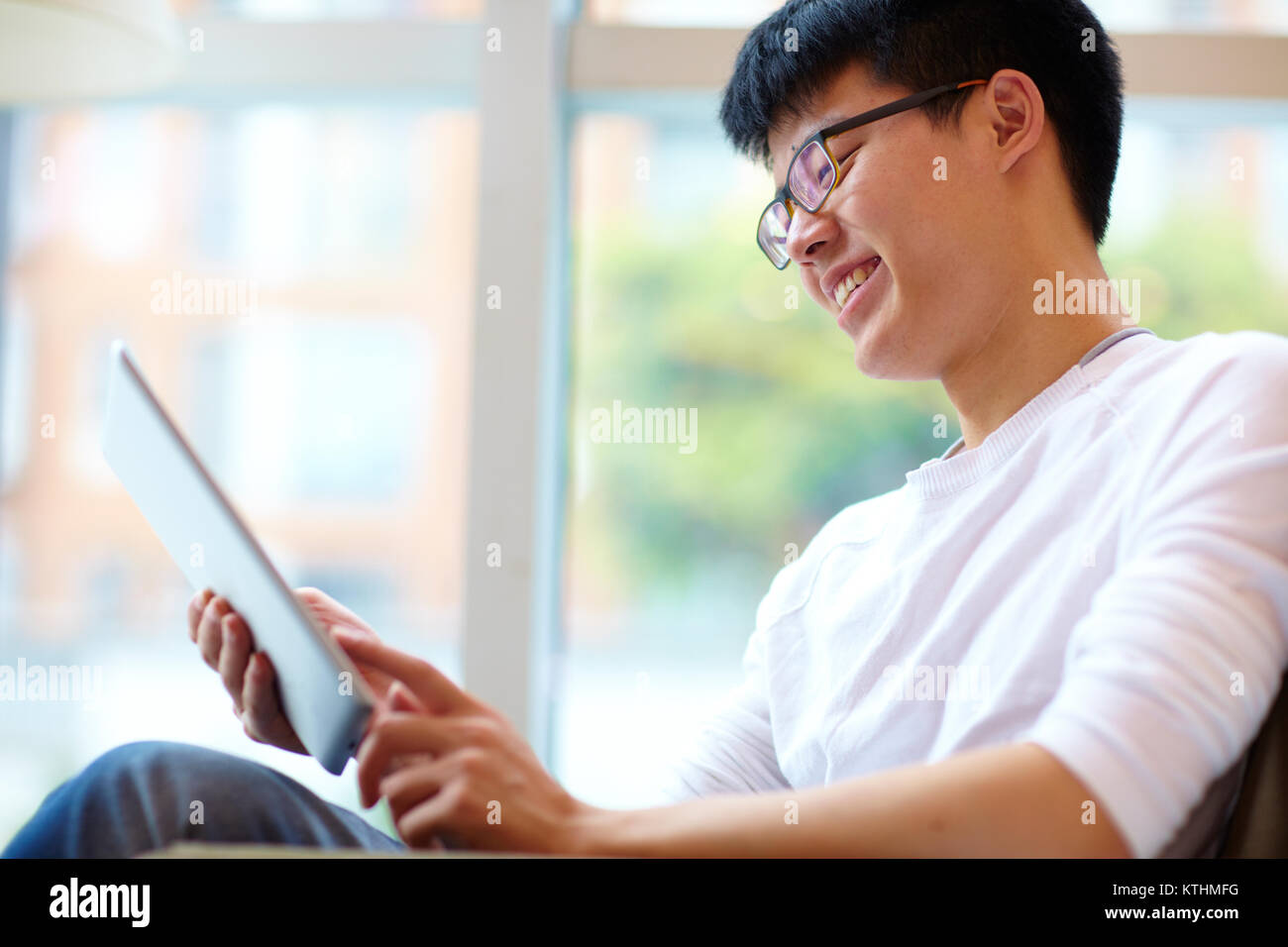 Chinesischen jungen Mann mit Tablette im Cafe Stockfoto
