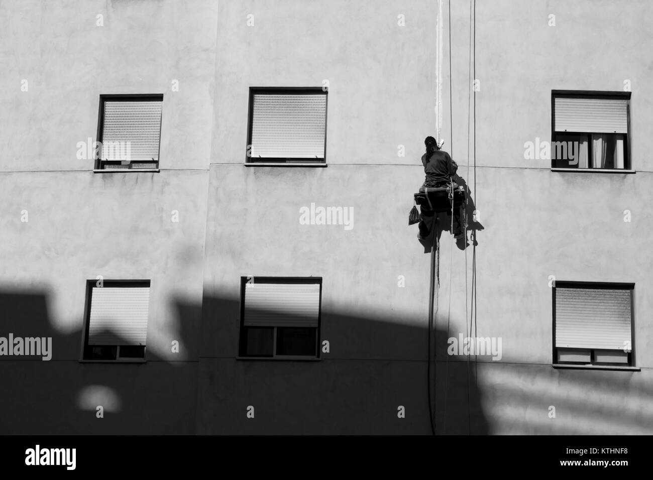 Der Arbeiter ist die Instandsetzung des Hauses in der Höhe. Estepona, Costa del Sol, Andalusien, Spanien. Bild genommen - 1. Dezember 2017. Stockfoto