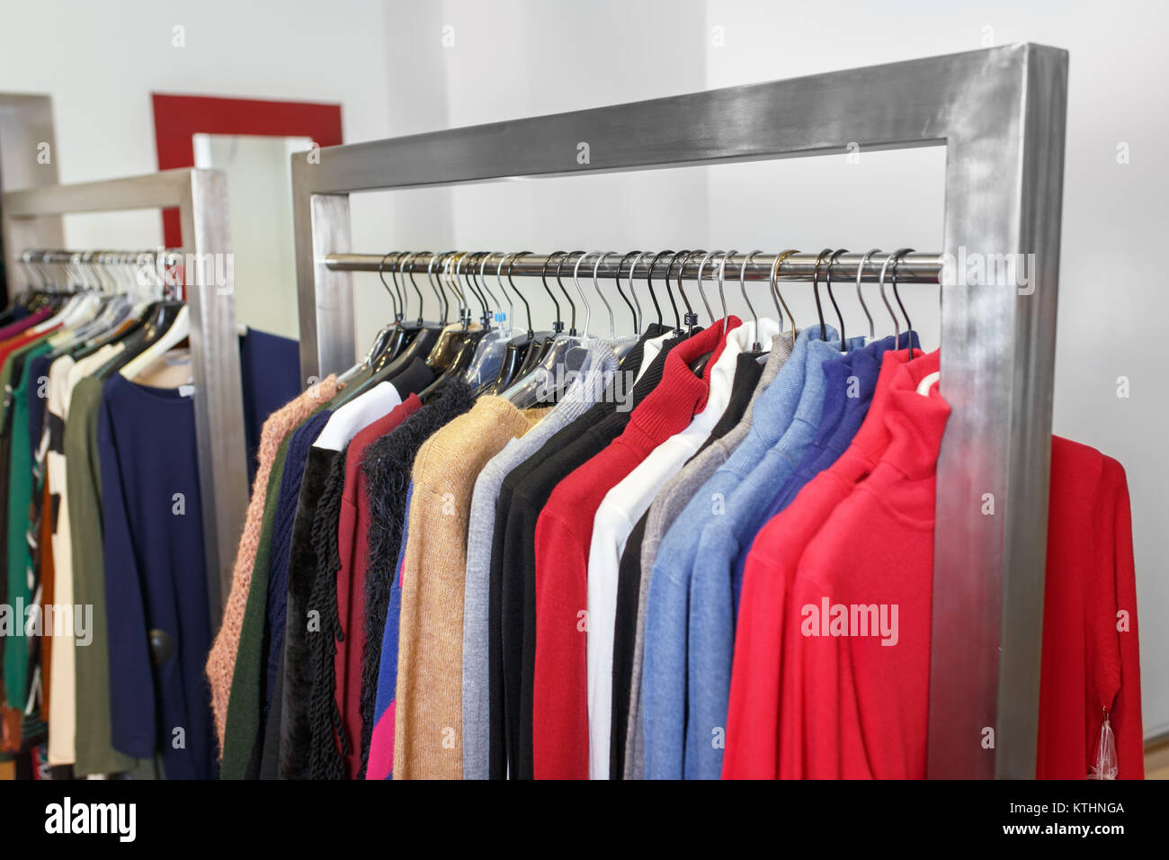 Kleiderbügel mit bunten Kleid in den Store. Kleidung aufhängen an Rack in der Mode Boutique. Shopping Konzept Stockfoto