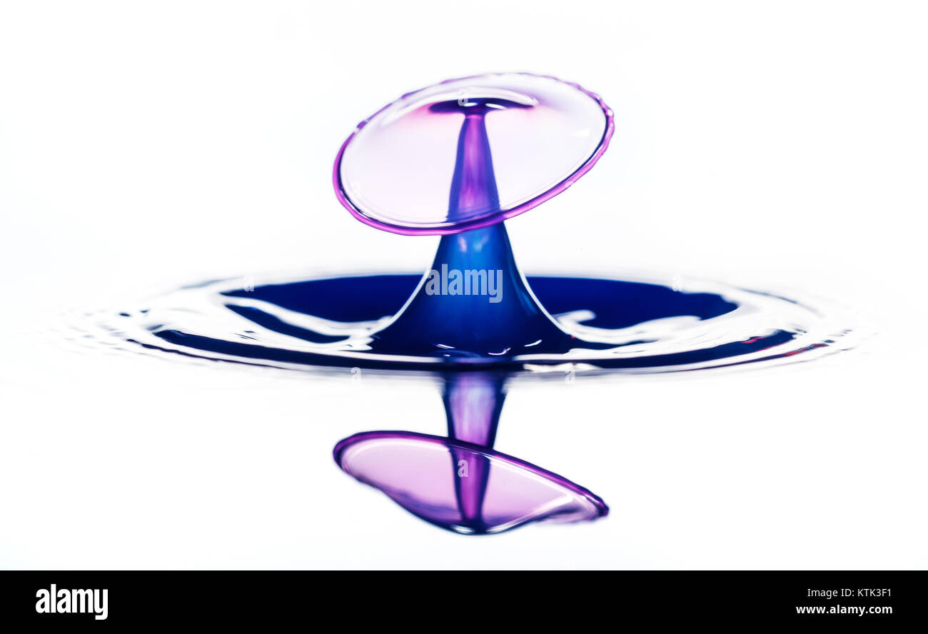 Splash und Krone auf wellenförmige blaue Flüssigkeit oder Wasser Oberfläche. Wasser mit einer Krone und Reflexion Stockfoto