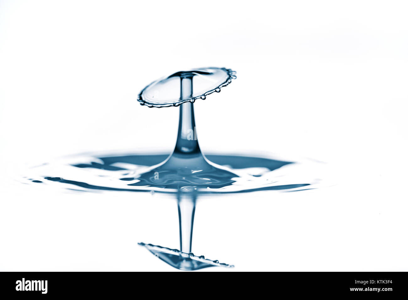 Splash und Krone auf wellenförmige blaue Flüssigkeit oder Wasser Oberfläche. Wasser mit einer Krone und Reflexion Stockfoto