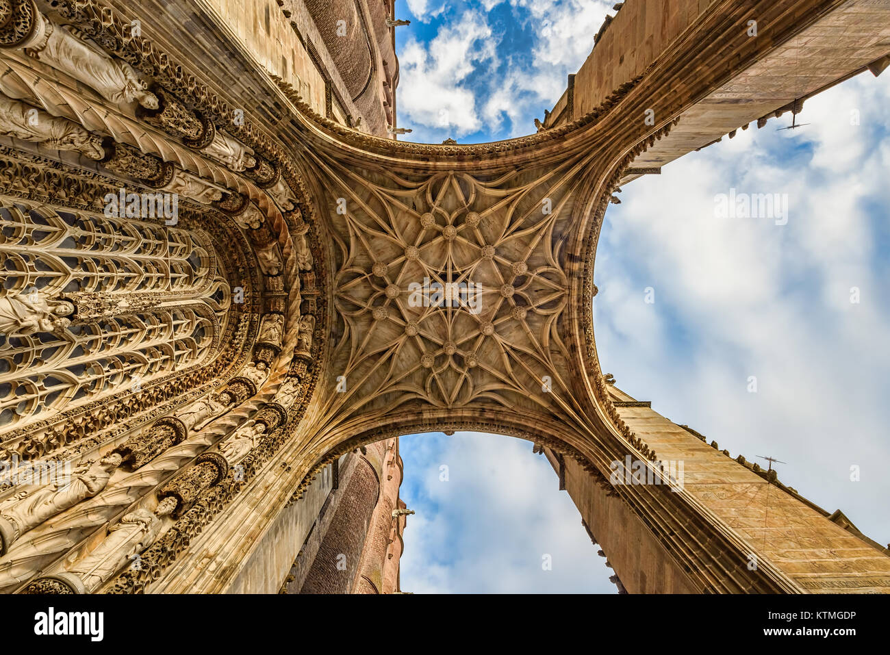 Detailansicht eines mittelalterlichen Kathedrale Eingang von Grund auf unter blauem Himmel mit flauschigen weissen Wolken Stockfoto