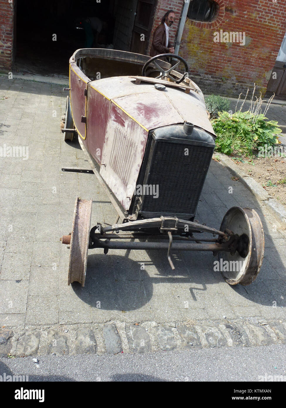 Aubenton in Aisne, Frankreich, ist bekannt für seine Geschichte und die Anwesenheit eines antiken Peugeot-Fahrzeugs, das Teil des lokalen Kulturerbes ist. Stockfoto