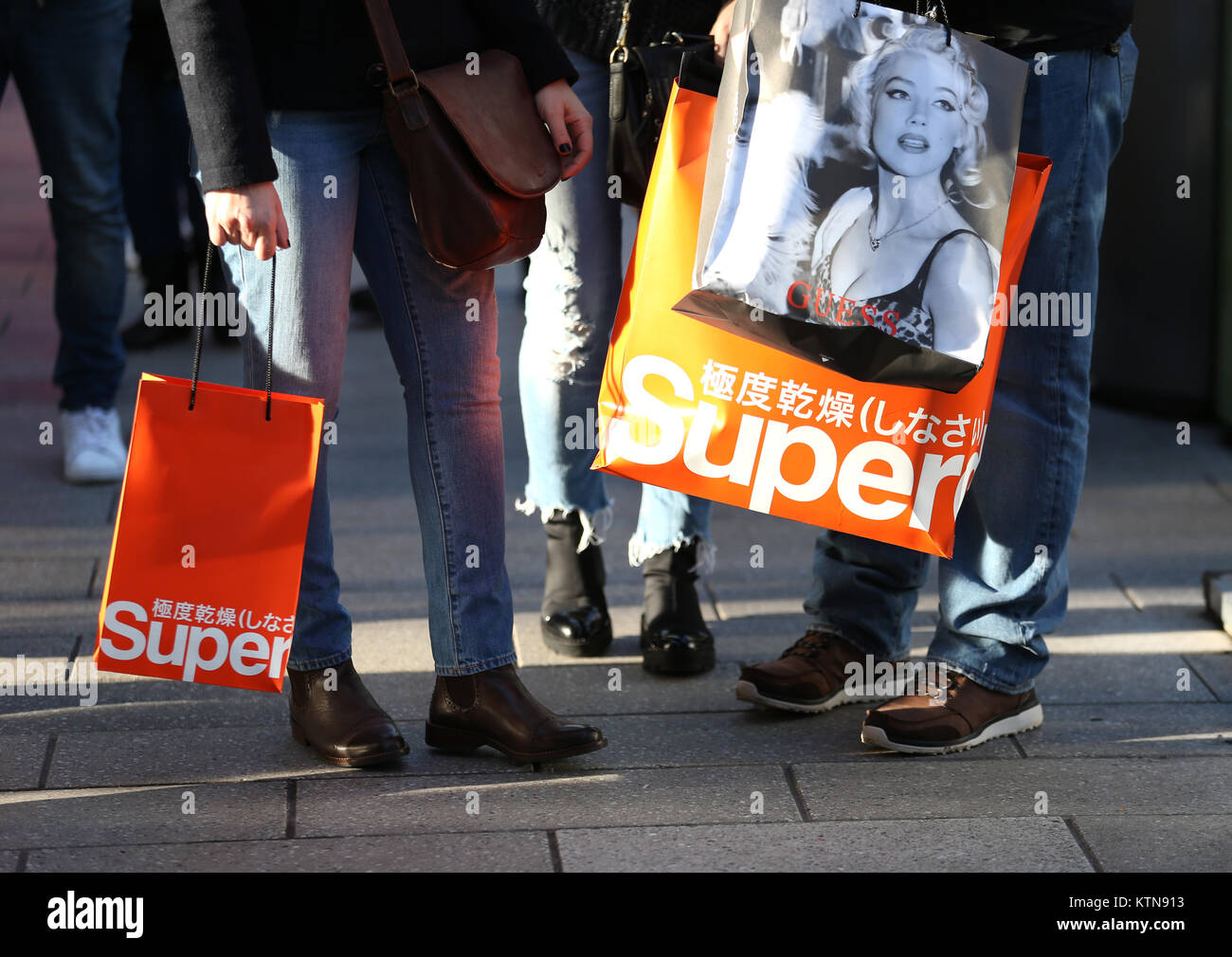 Käufer, die Einkäufe von Superdry und Vermutung, nach dem Besuch der Boxing Day in London. Stockfoto