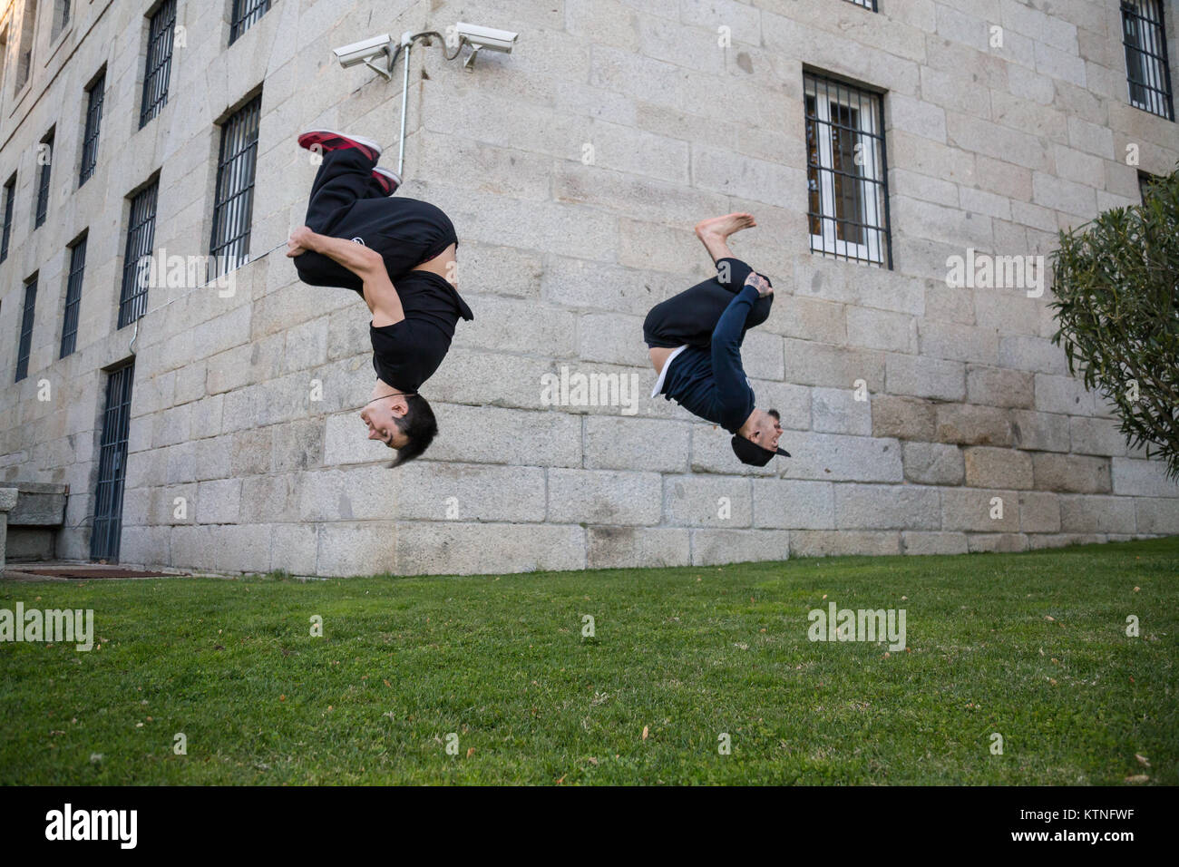Zwei junge Männer eine Seite blättern oder Salto während Sie üben Parkour auf der Straße. Stockfoto