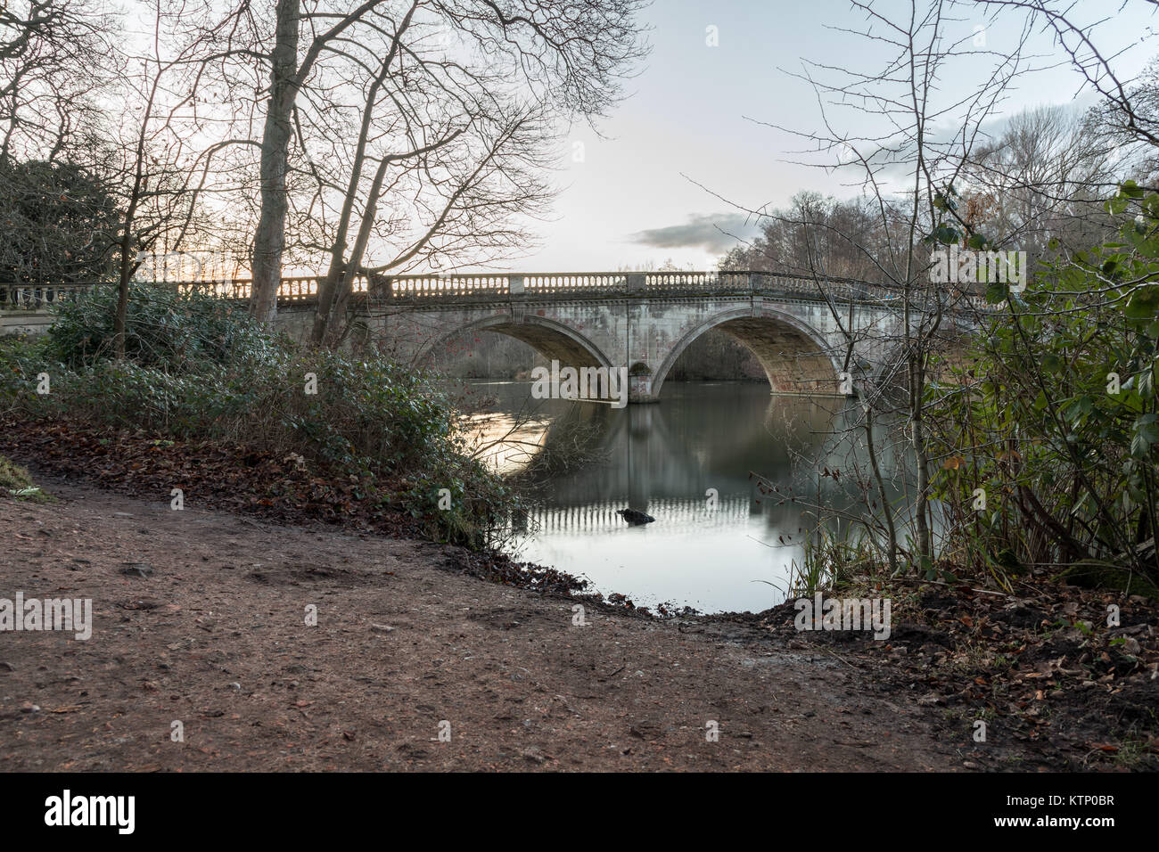 Clumber Park Bridge bei Sonnenuntergang. Spiegelbild im Wasser an Clumber Park, Worksop, Nottinghamshire Stockfoto