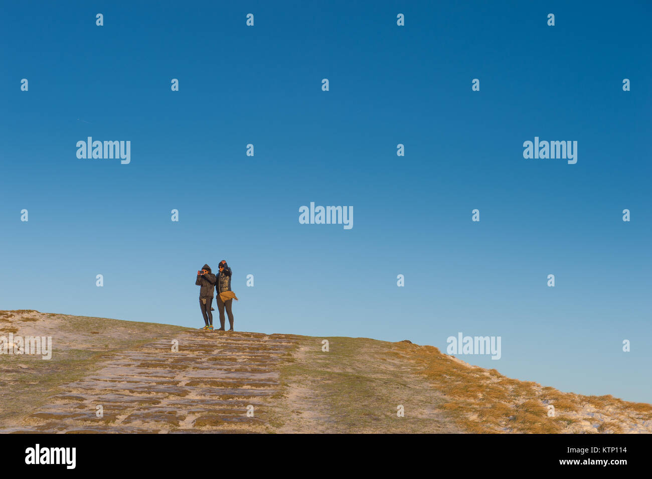 Castleton, UK. 28 Dez, 2017. Zwei Frauen, die ein Foto von der Landschaft mit einem Mobiltelefon auf dem Hügel von Mam Tor, in der Nähe von Castleton, Derbyshire am Donnerstag, den 28. Dezember 2017. Quelle: Matthew Wilkinson/Alamy leben Nachrichten Stockfoto