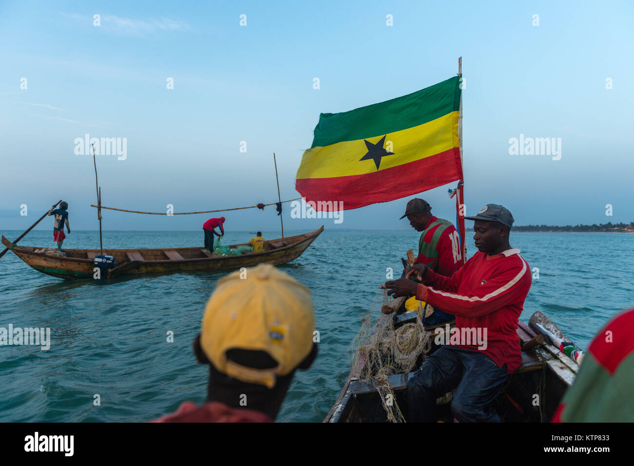 Die Fischer in ihren offenen Boot angeln in den frühen Morgen. Sie Schaufel von Netz zu Netz Ihre verfangen, Kokrobite, Greater Accra Region, Ghana zu holen Stockfoto