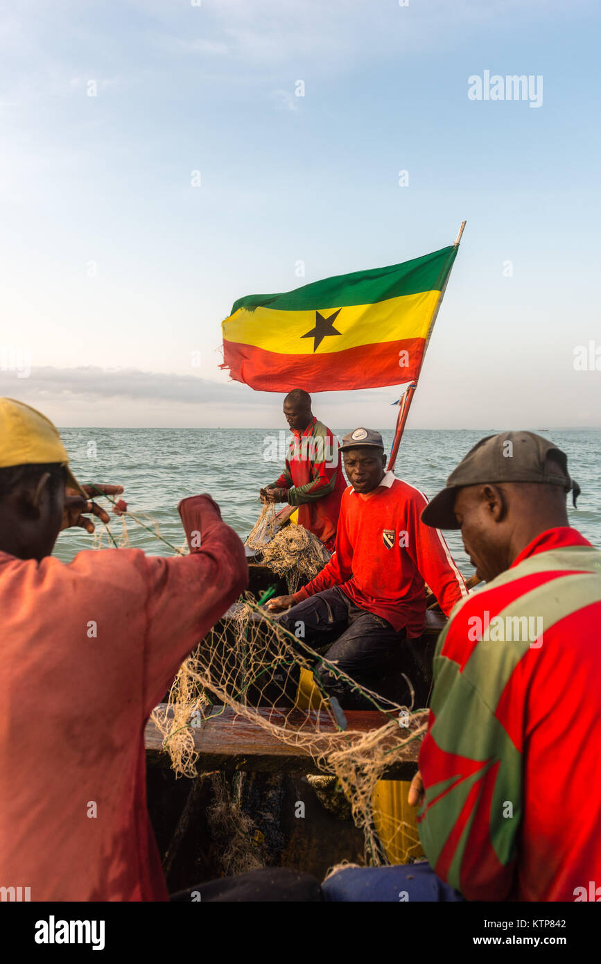 Die Fischer in ihren offenen Boot angeln in den frühen Morgen. Sie Schaufel von Netz zu Netz Ihre verfangen, Kokrobite, Greater Accra Region, Ghana zu holen Stockfoto